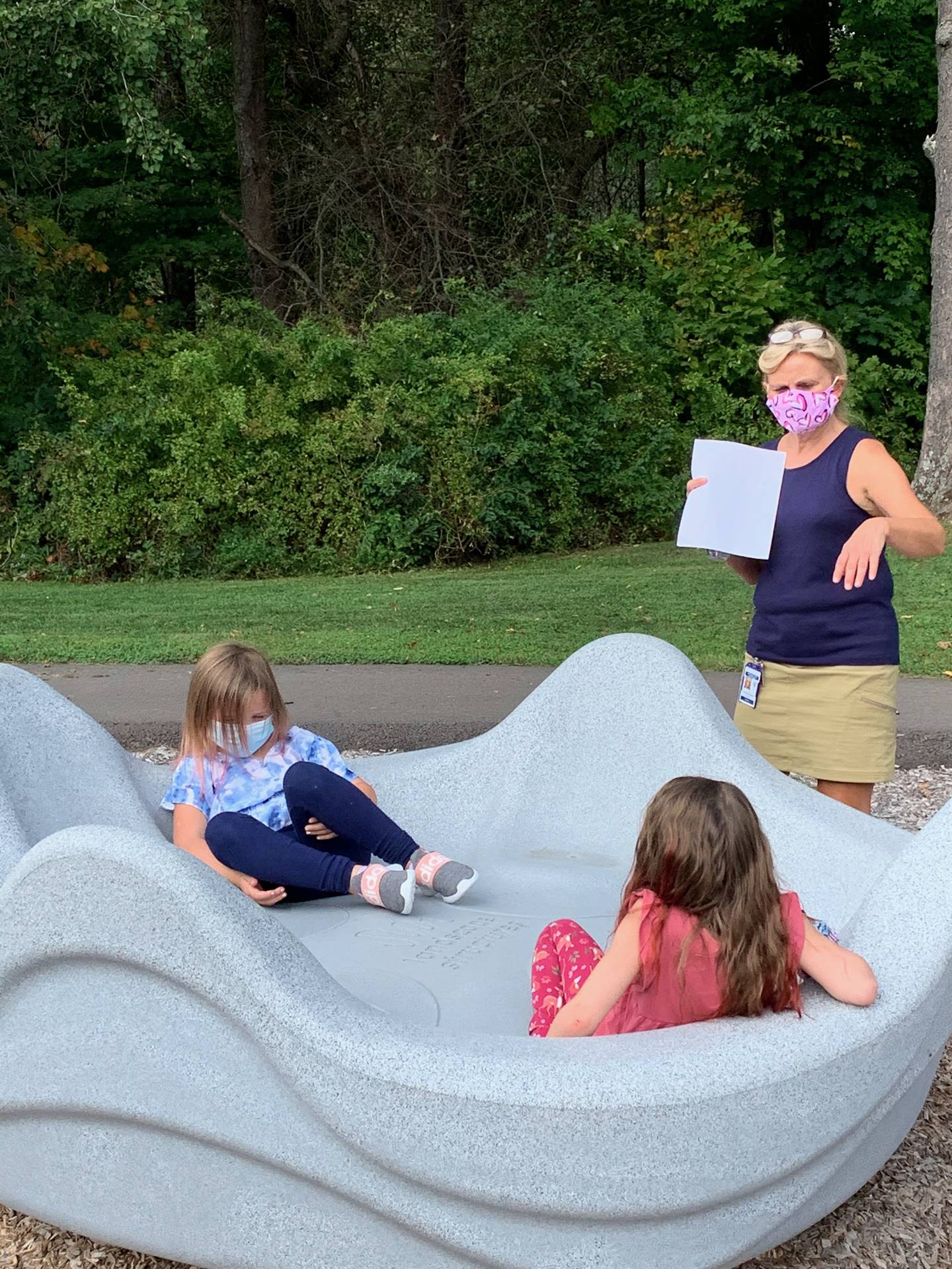 A teacher spins students on clam ride.