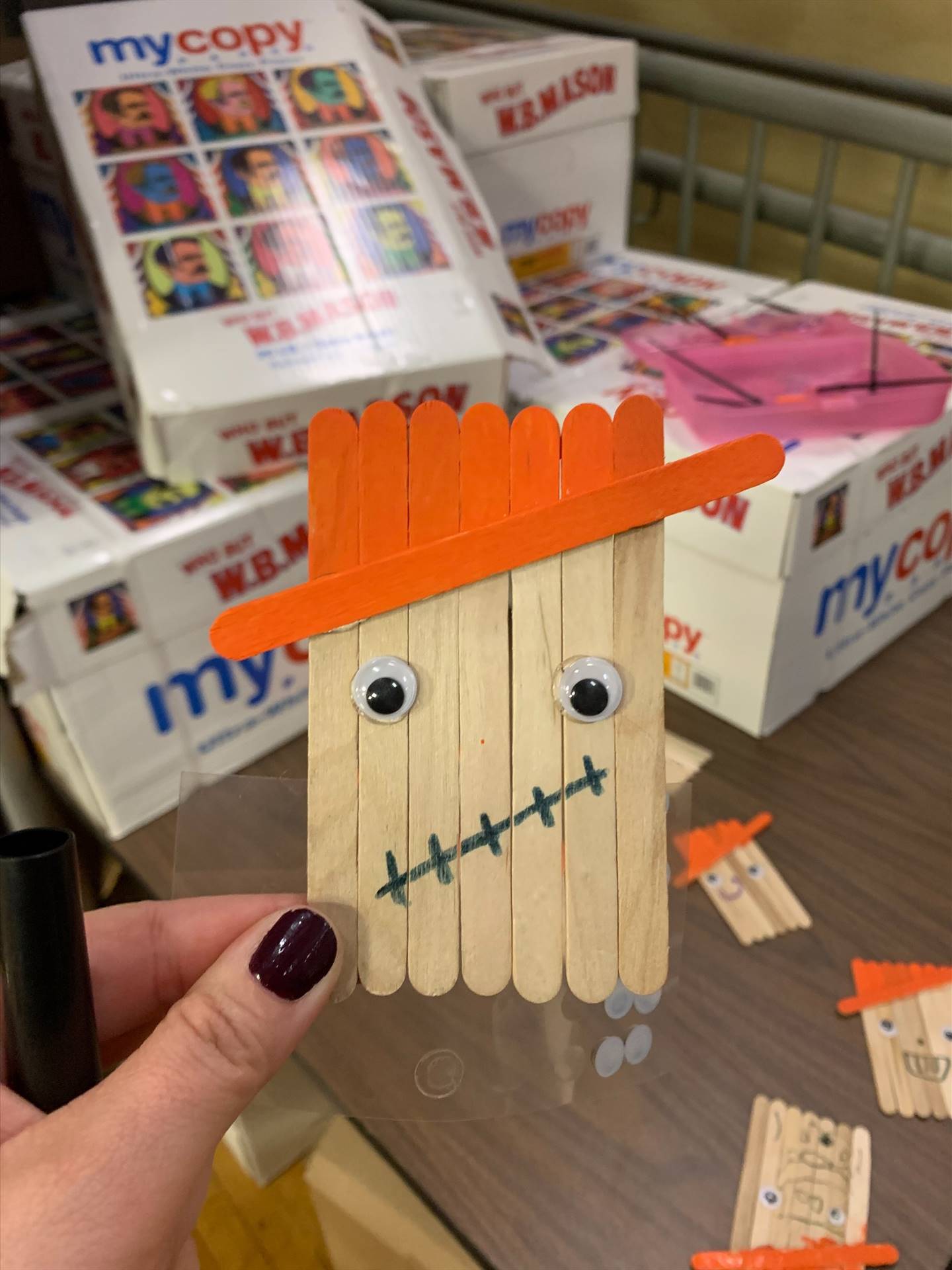 A scarecrow popsicle craft with orange hat. 