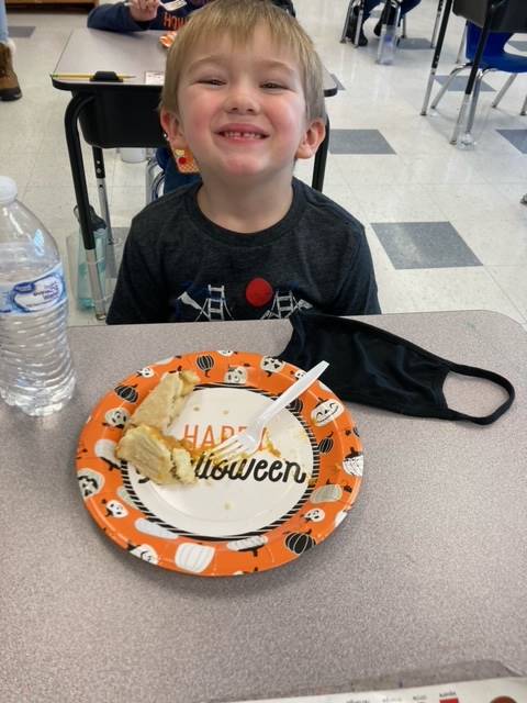 child with pumpkin pie on a plate.