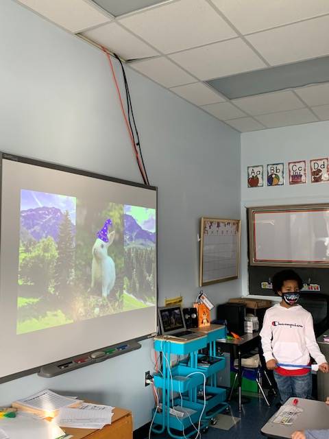 student standing by smart board giving a presentation