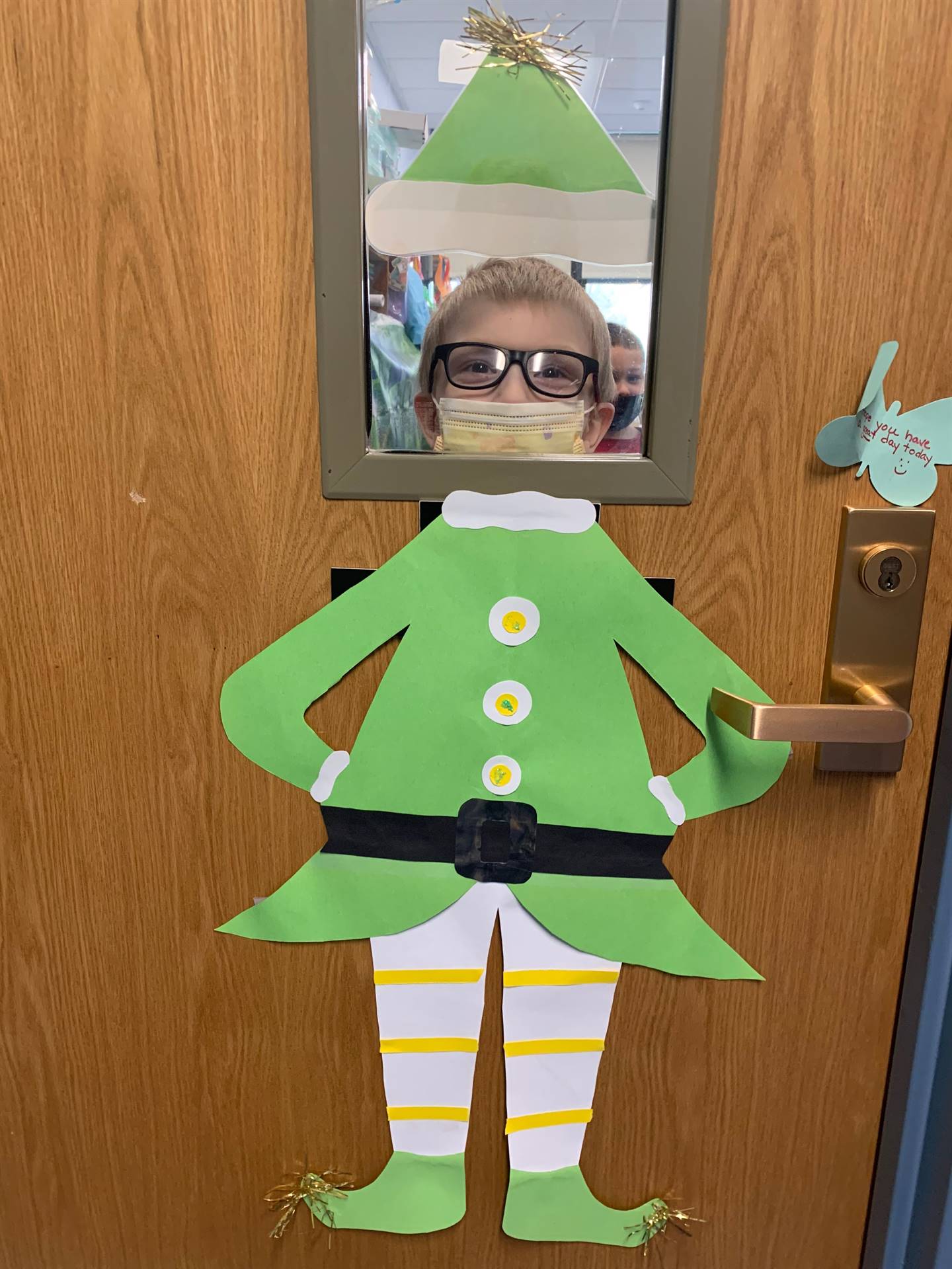 a student dressed as an elf with green top and white trousers with yellow stripes