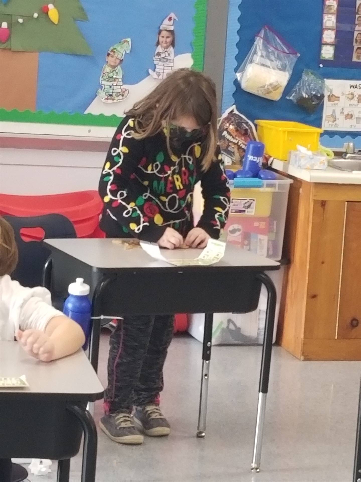 student standing behind desk working with play do