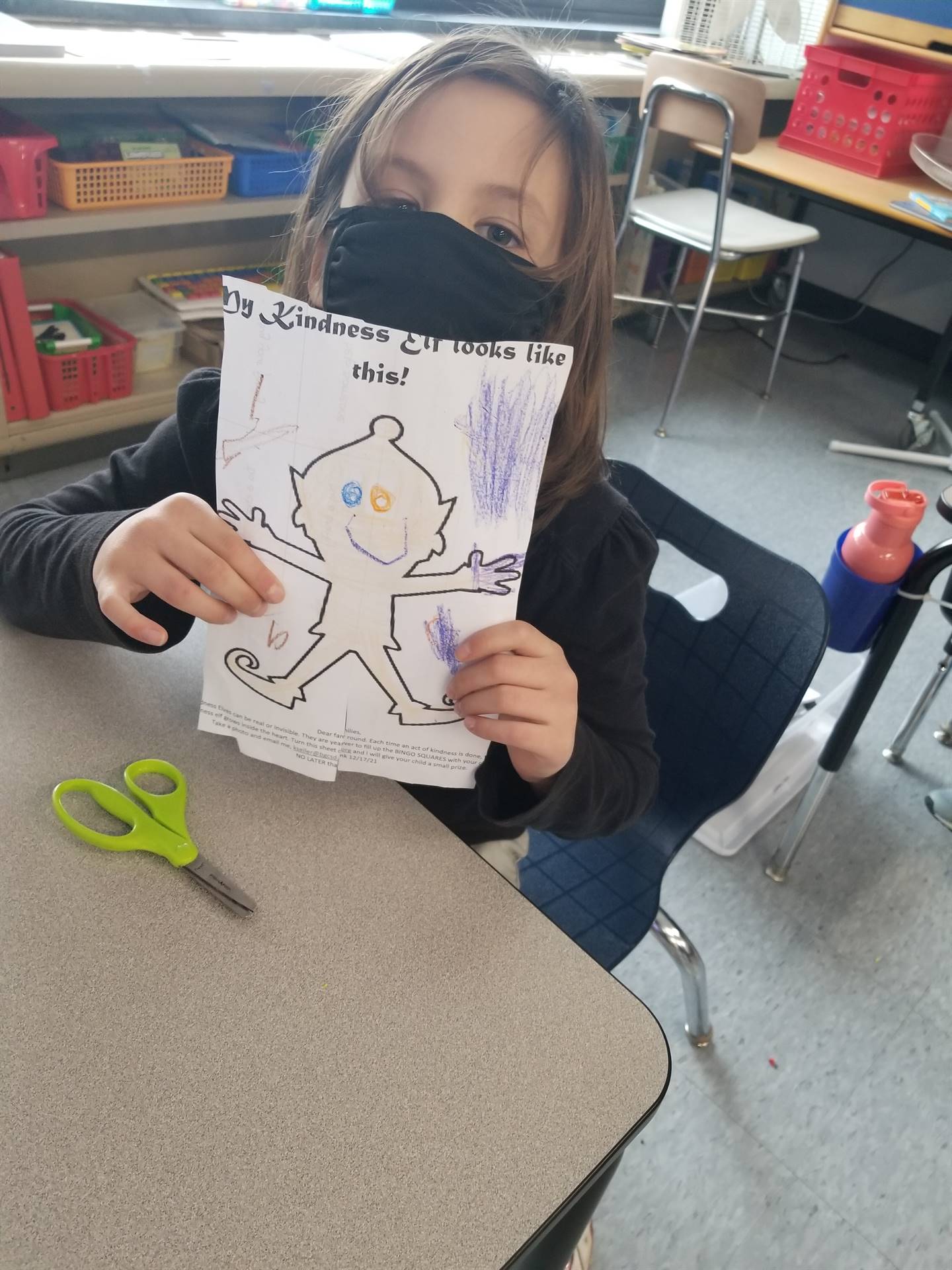 child holding up a colored picture of an elf.