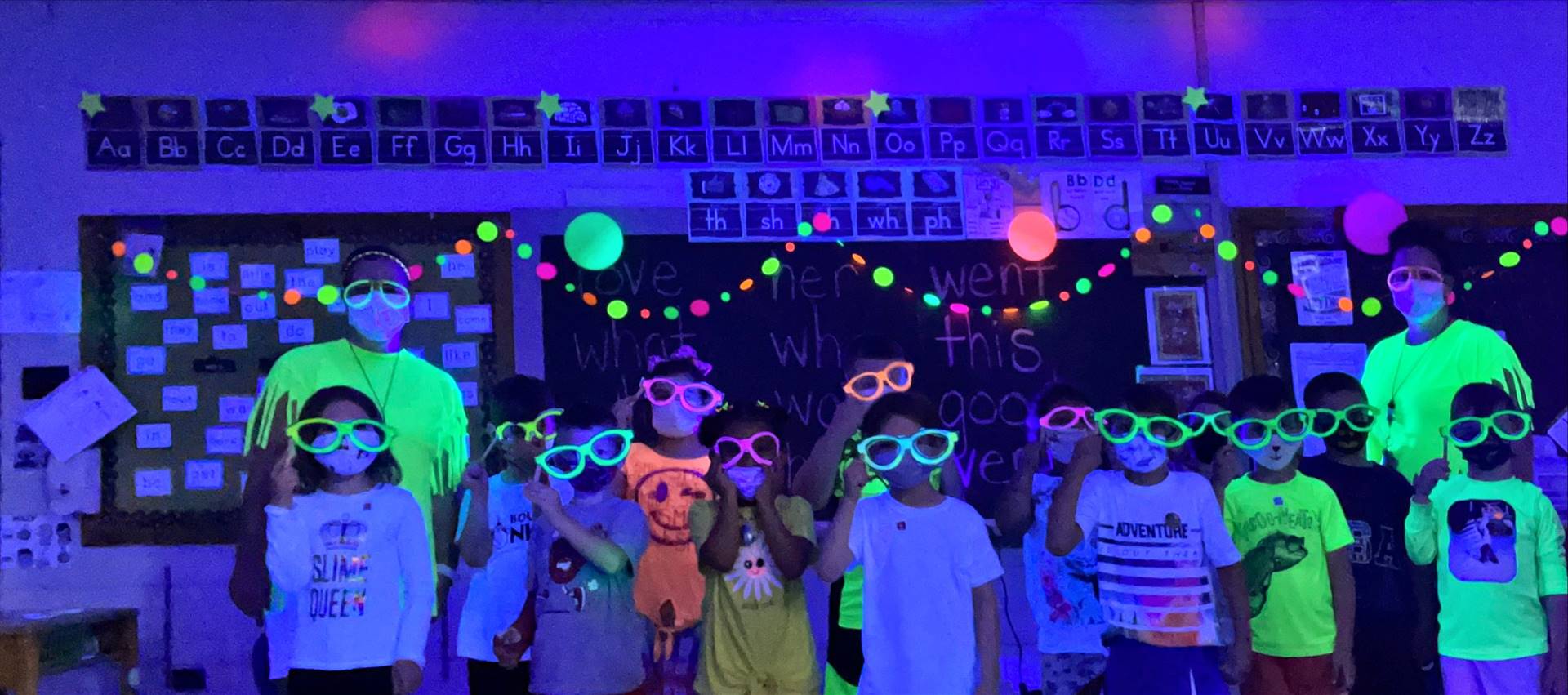 Staff and students with glow glasses on .