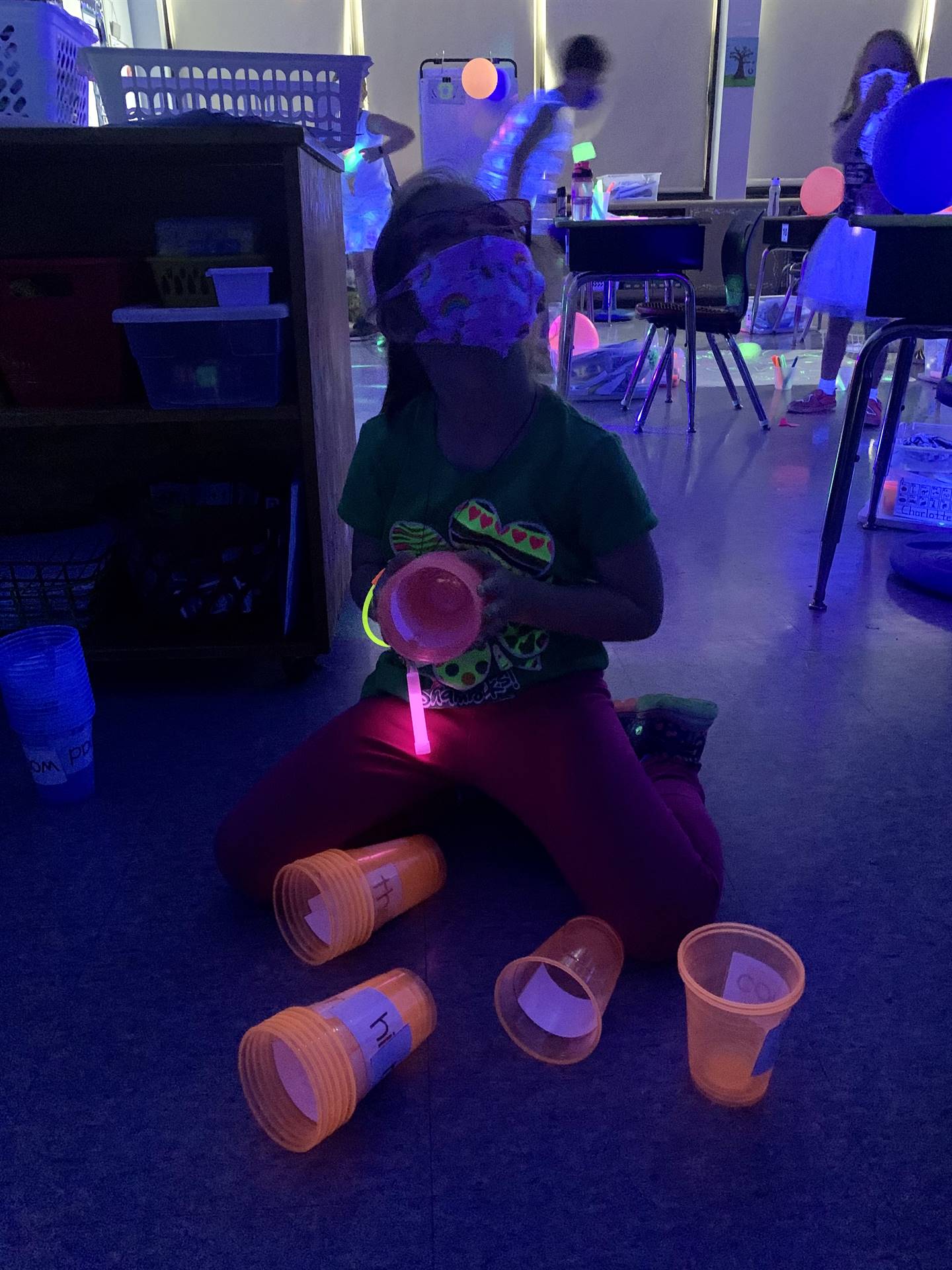 a student with glow up cups