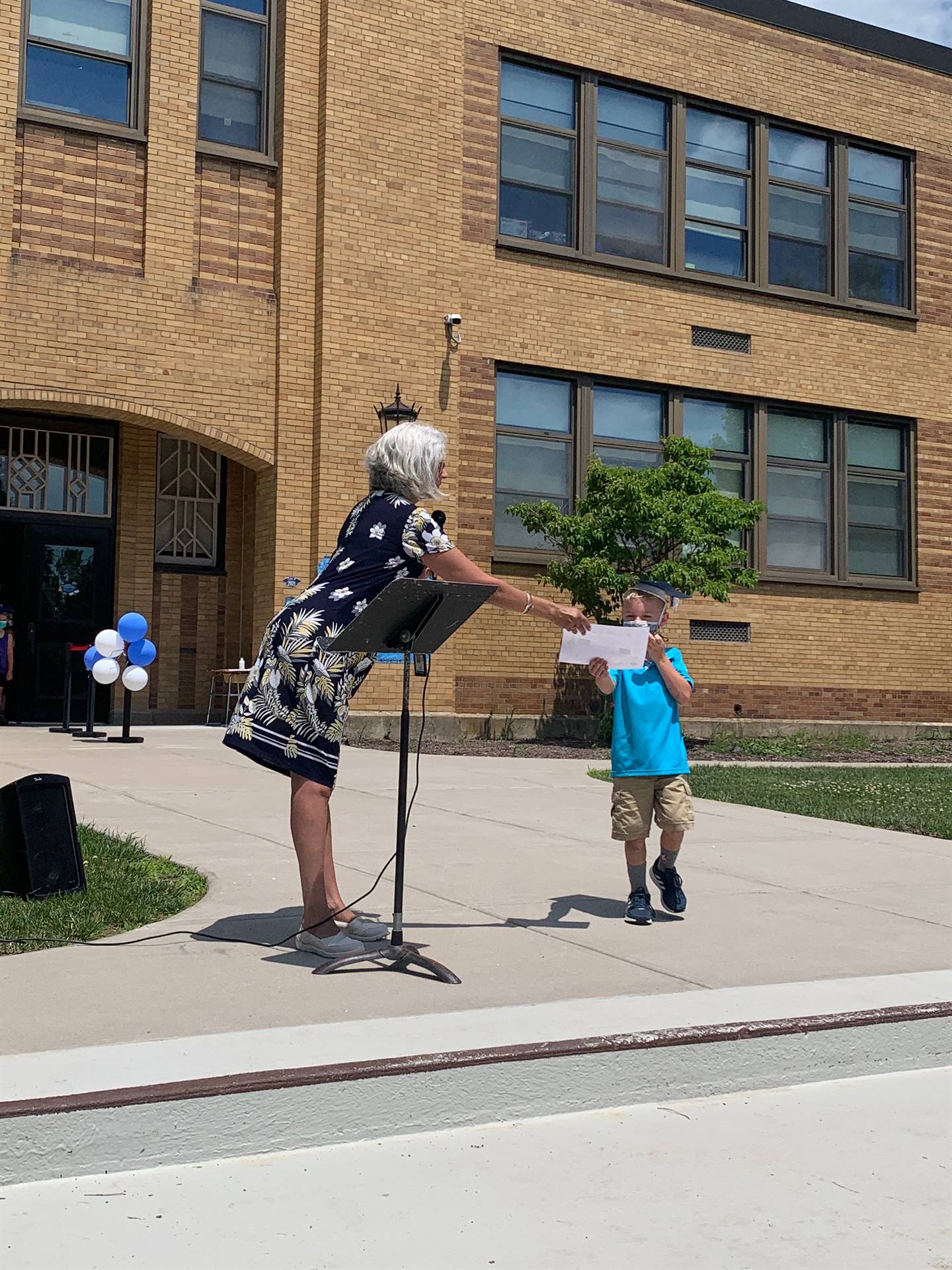 Principal hands certificate to student