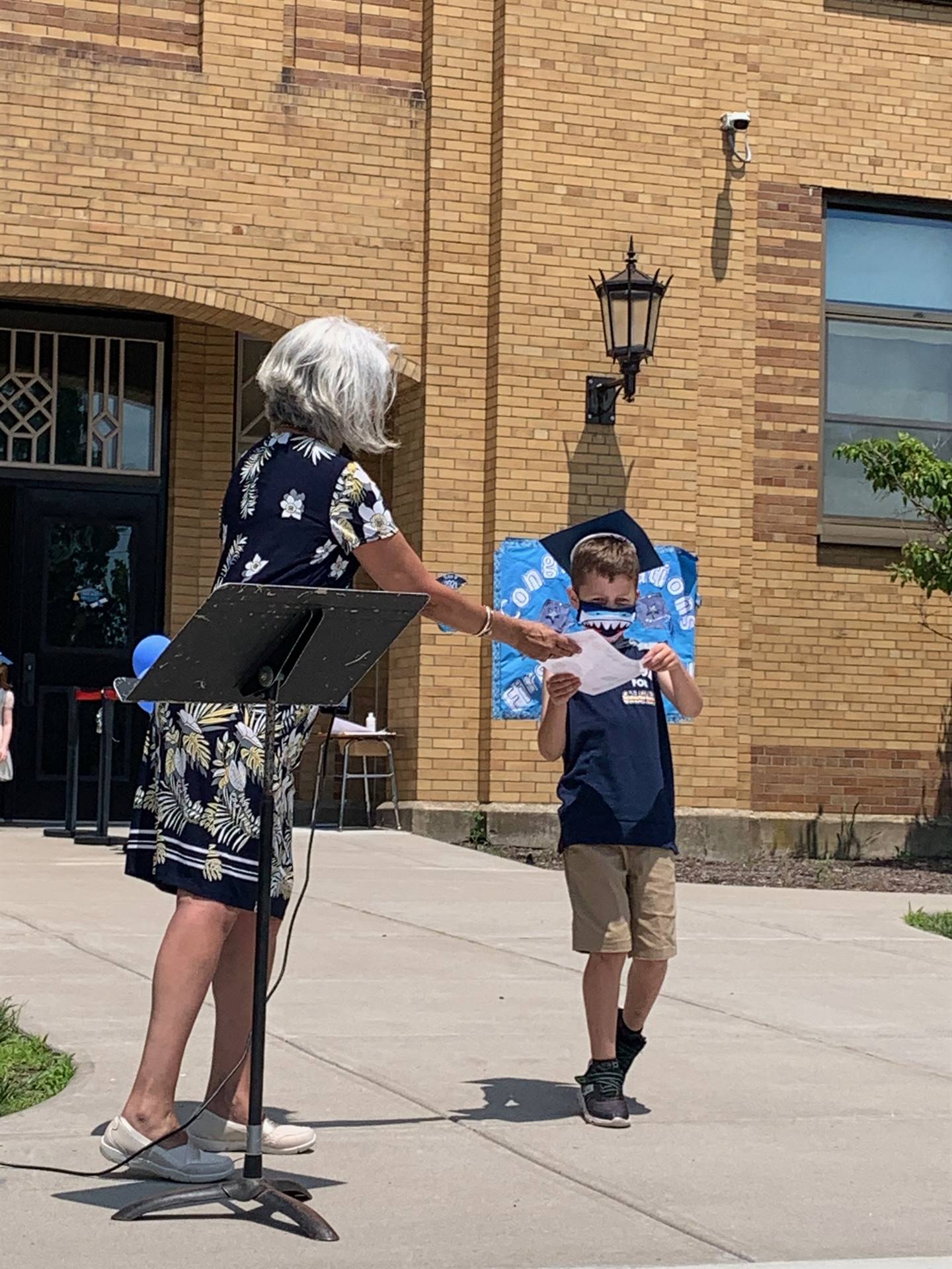 Principal hands certificate to student