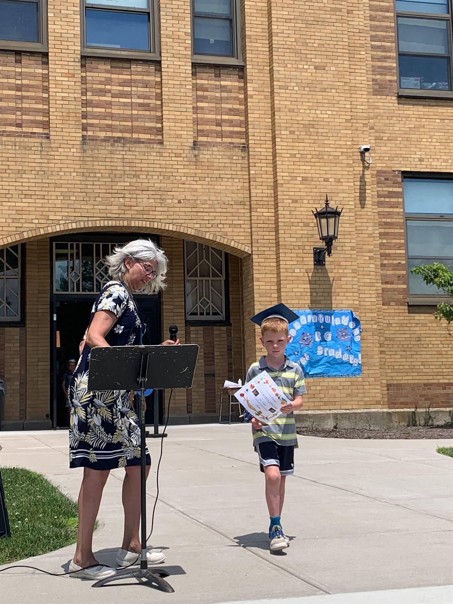 Principal hands certificate to student