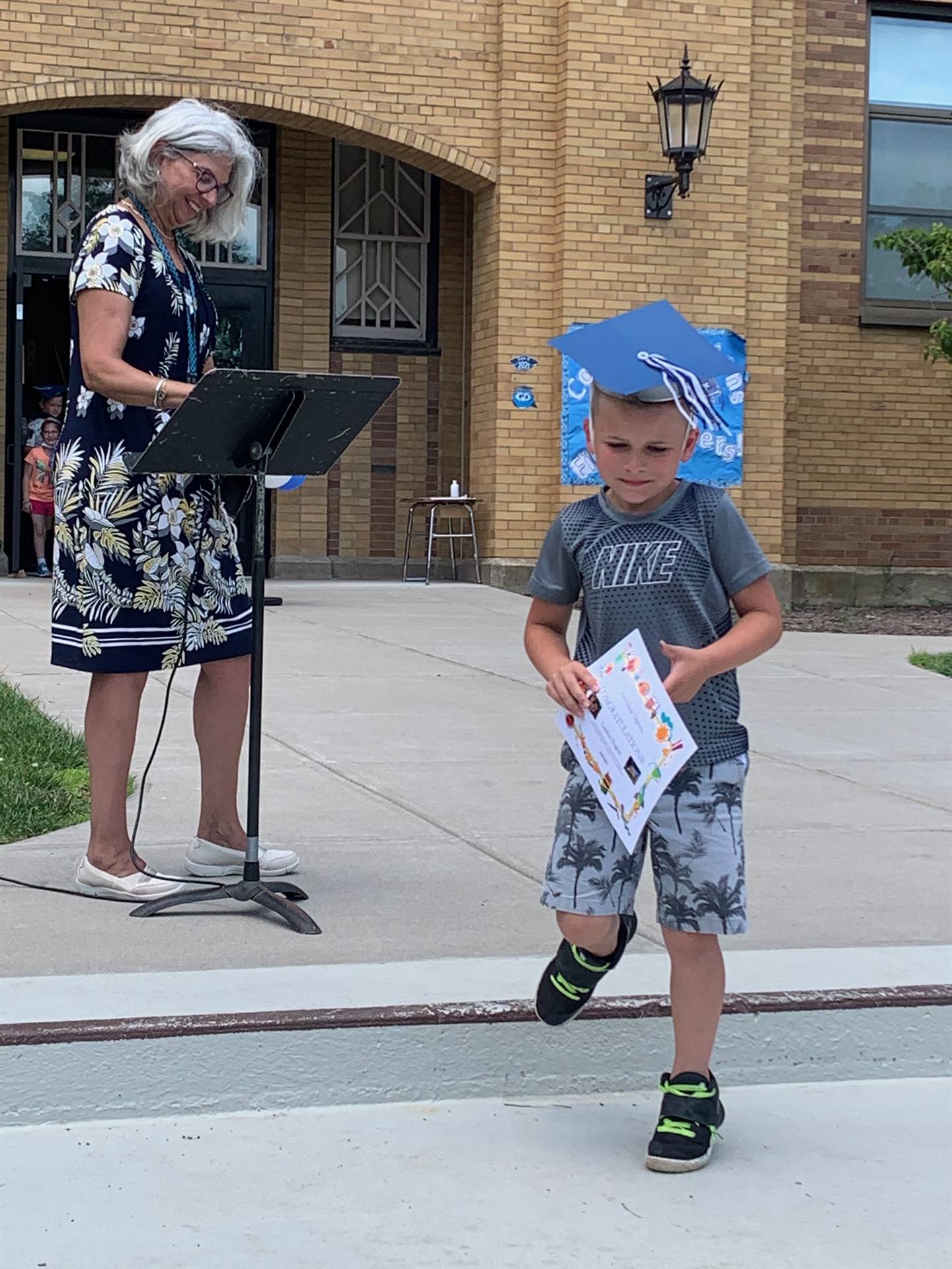 Principal hands certificate to student