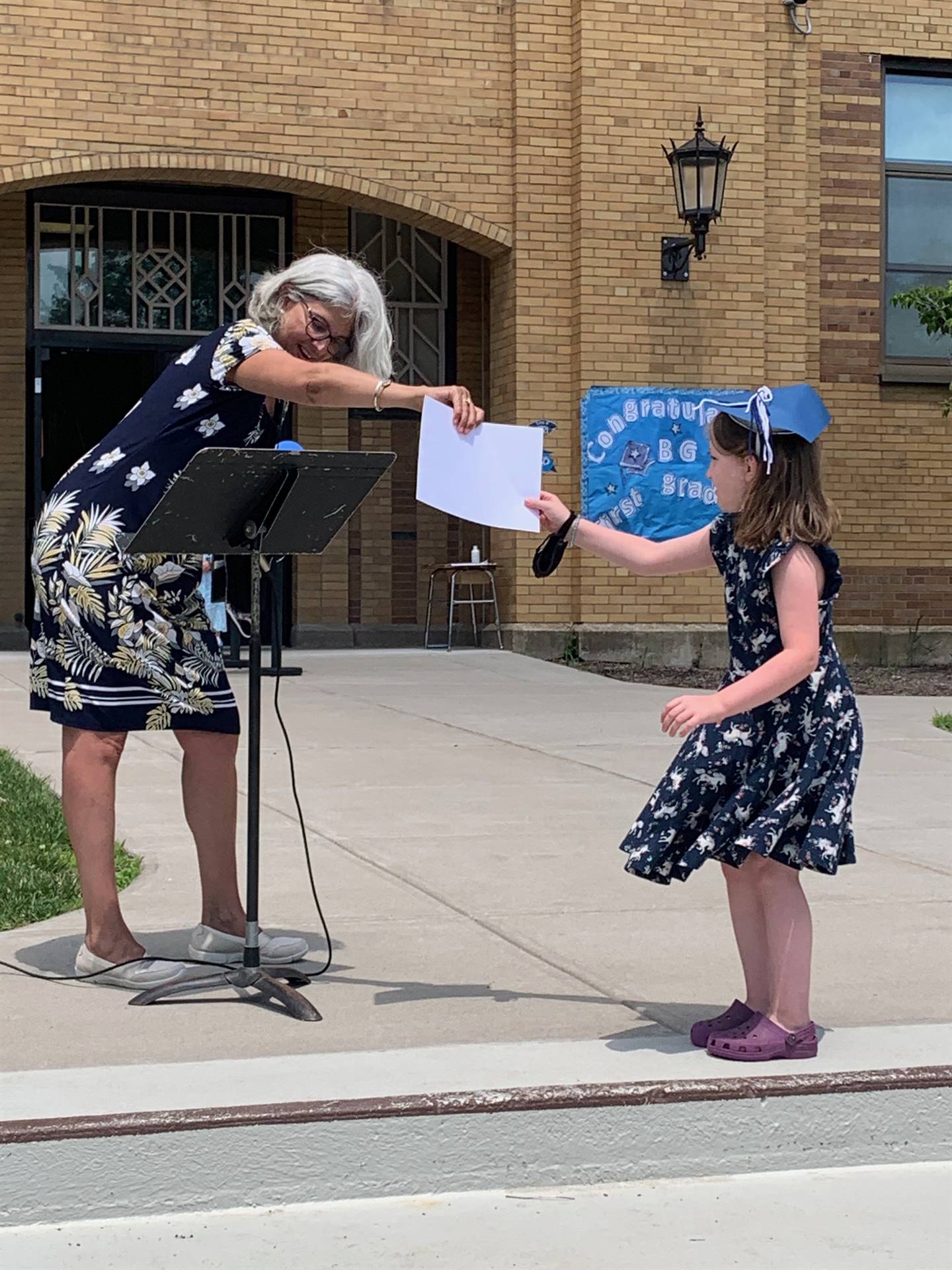 Principal hands certificate to student