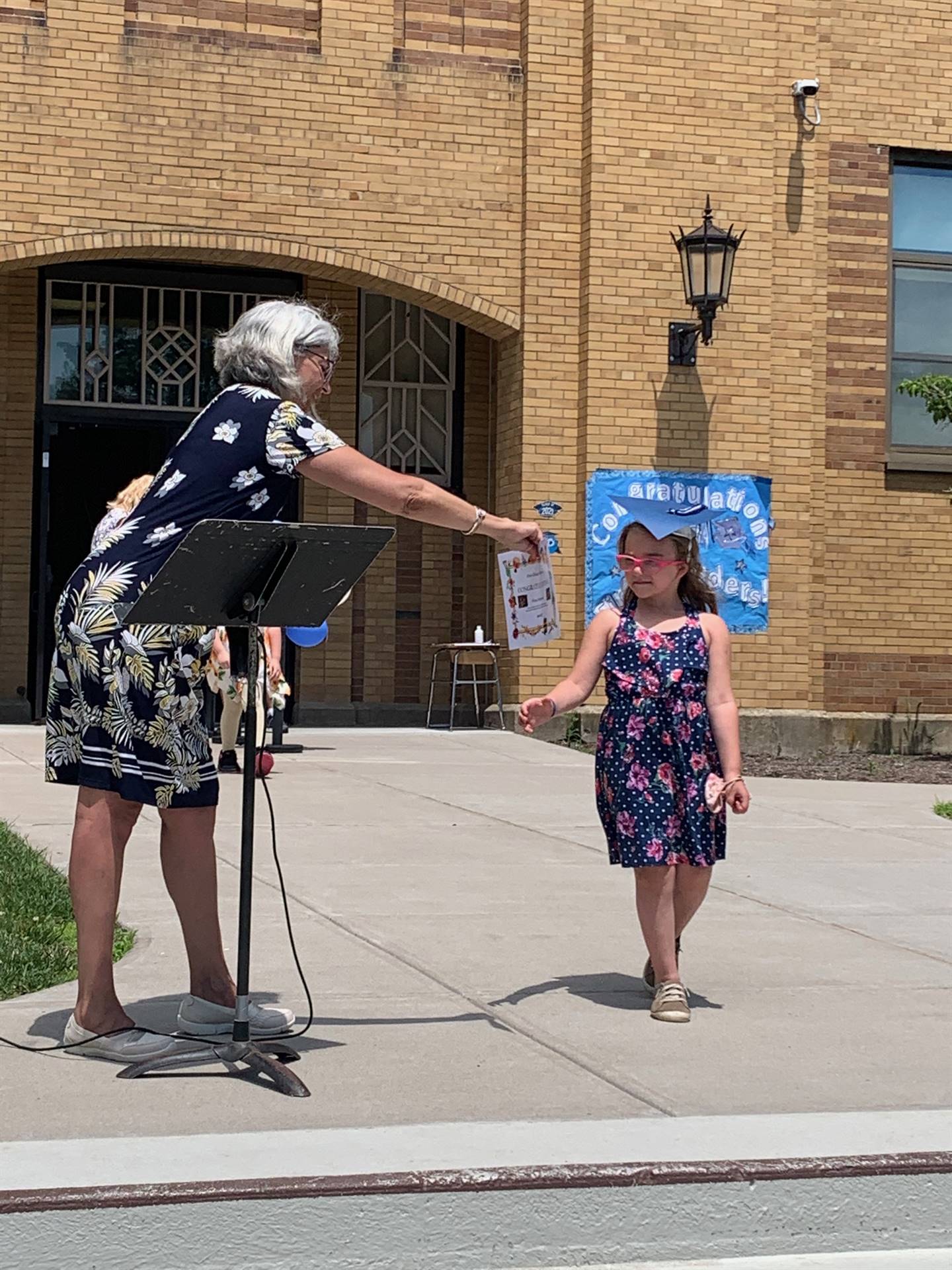 Principal hands certificate to student