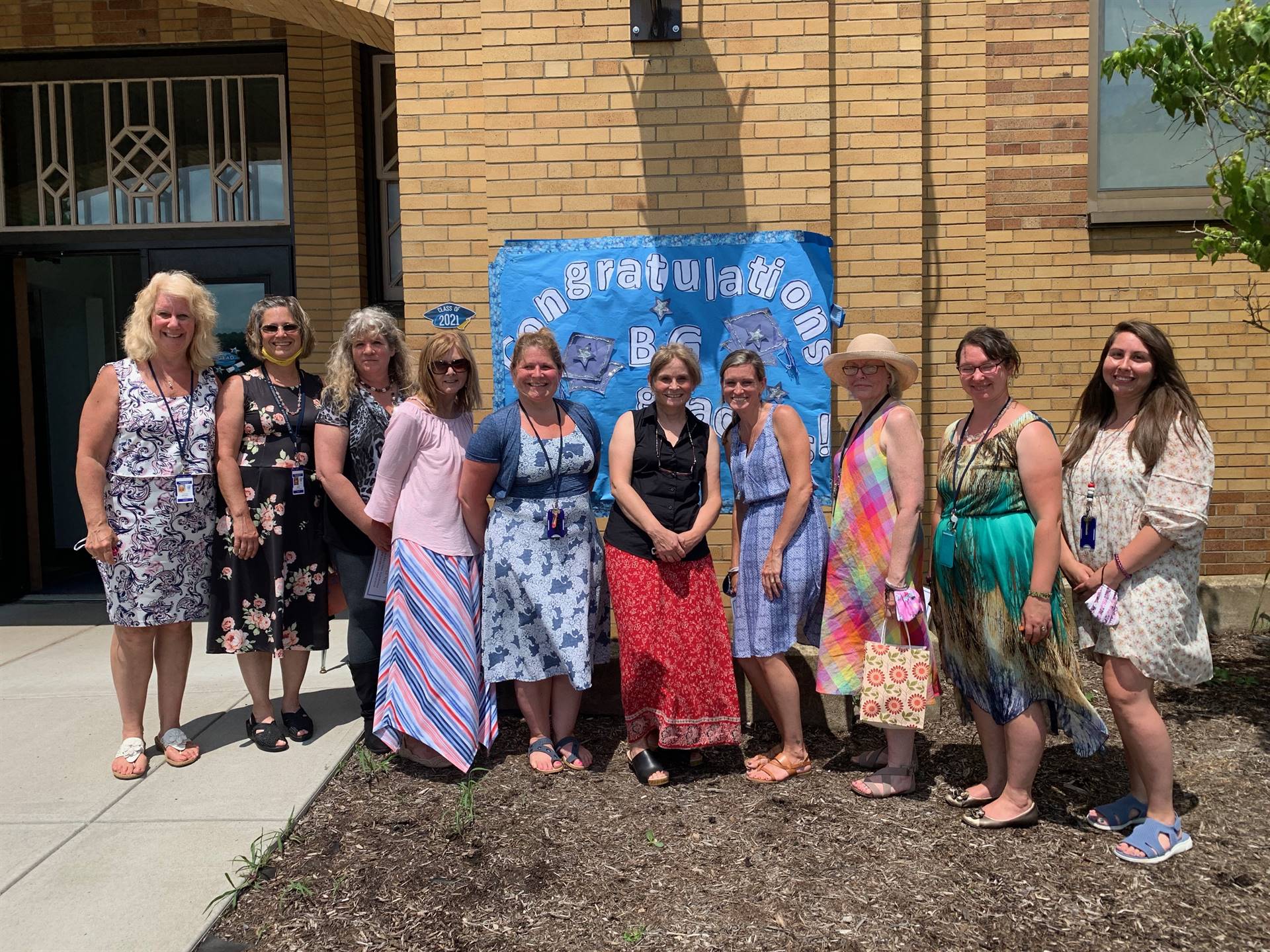 first grade staff in front of sign on building