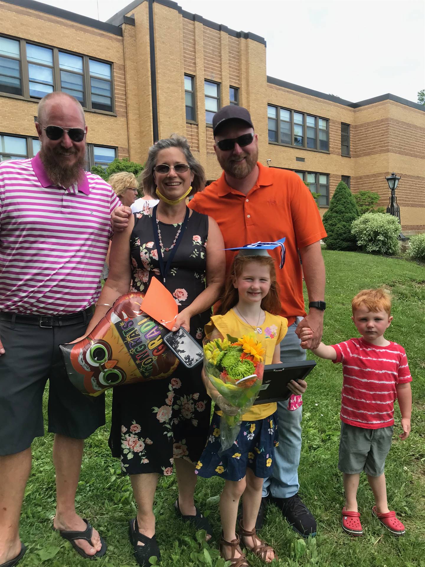 3 adults and 2 kids post graduation photo