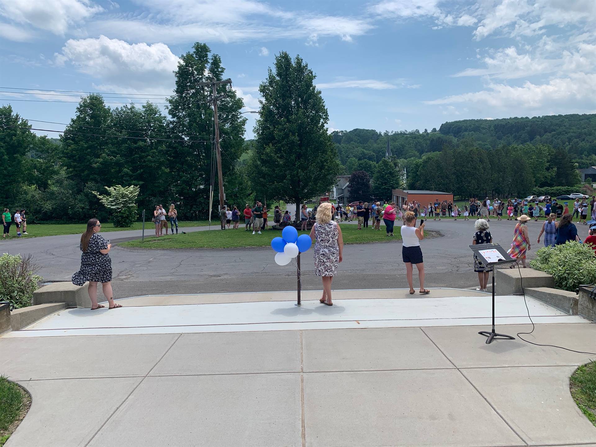 Looking out onto driveway circle as students parade and adults watch.