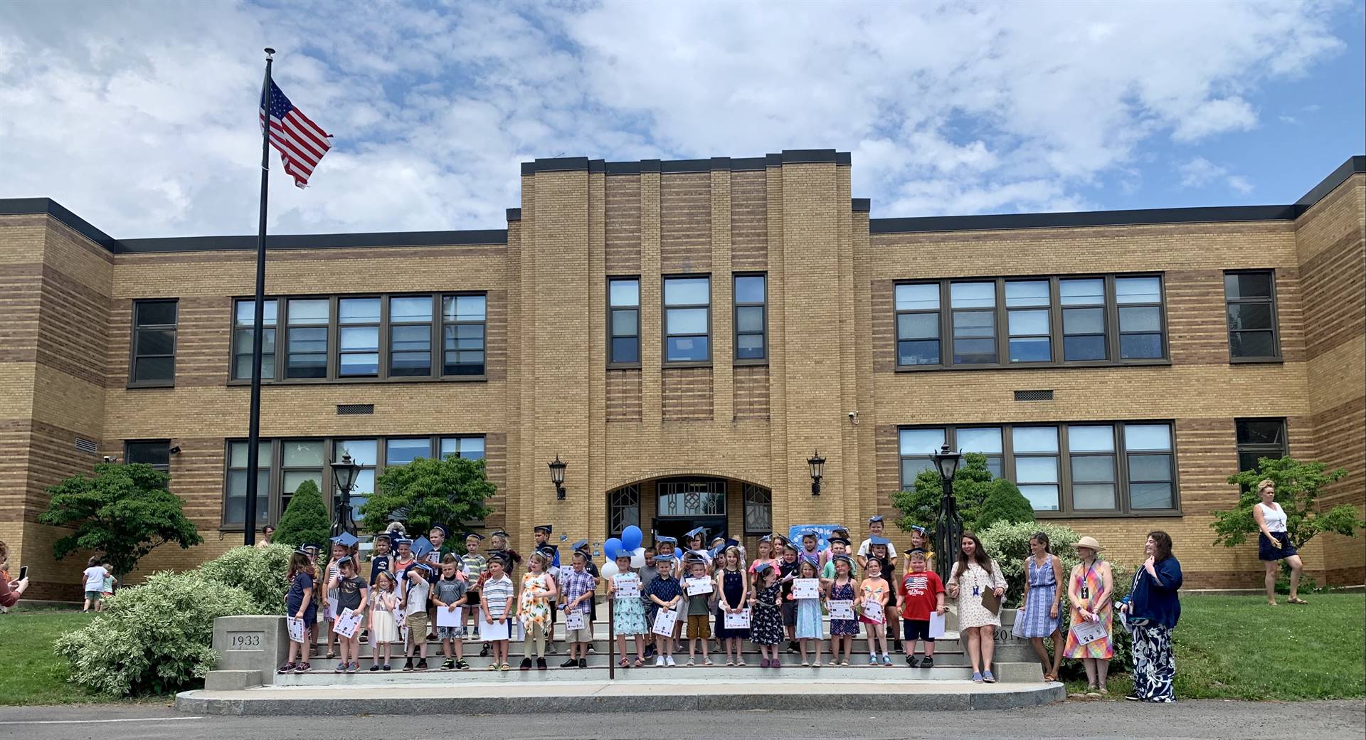 students and staff in front of guilford building stand on steps.