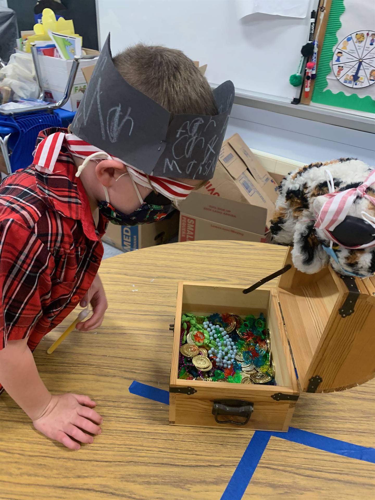 a student looks into treasure box with I care cat puppet watching.