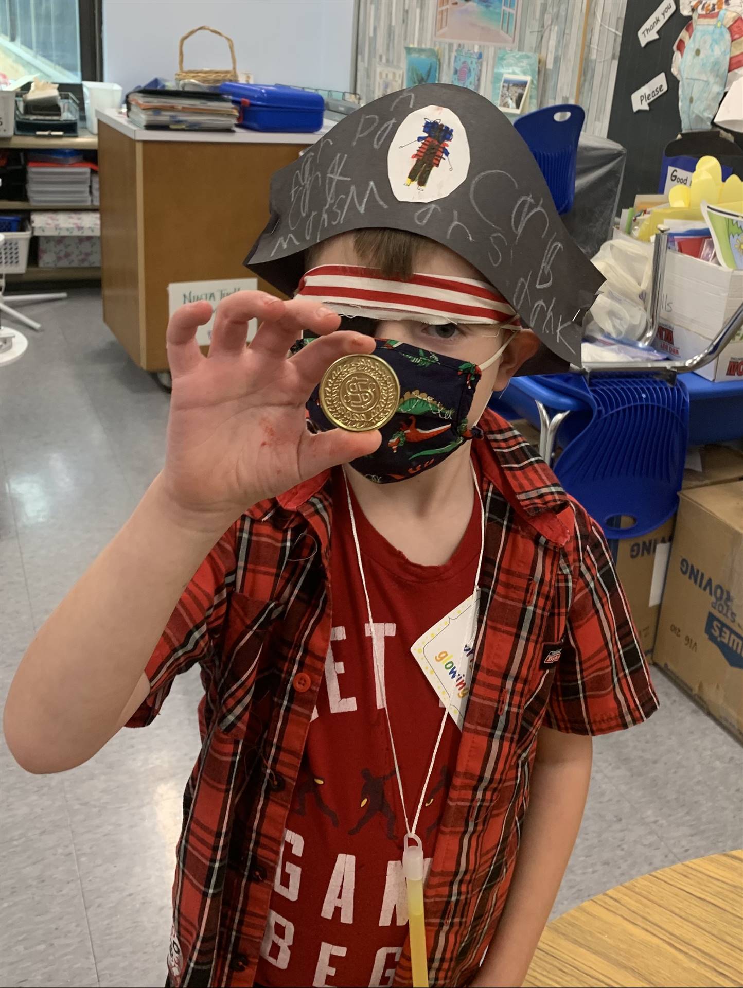 a student pirate holds up the treasured gold coin!