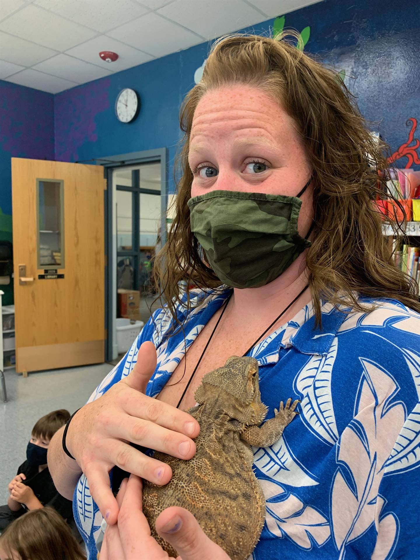 a teacher holds a reptile