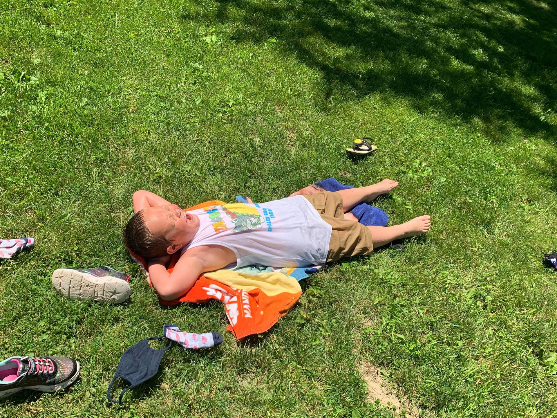 student laying on a beach towel