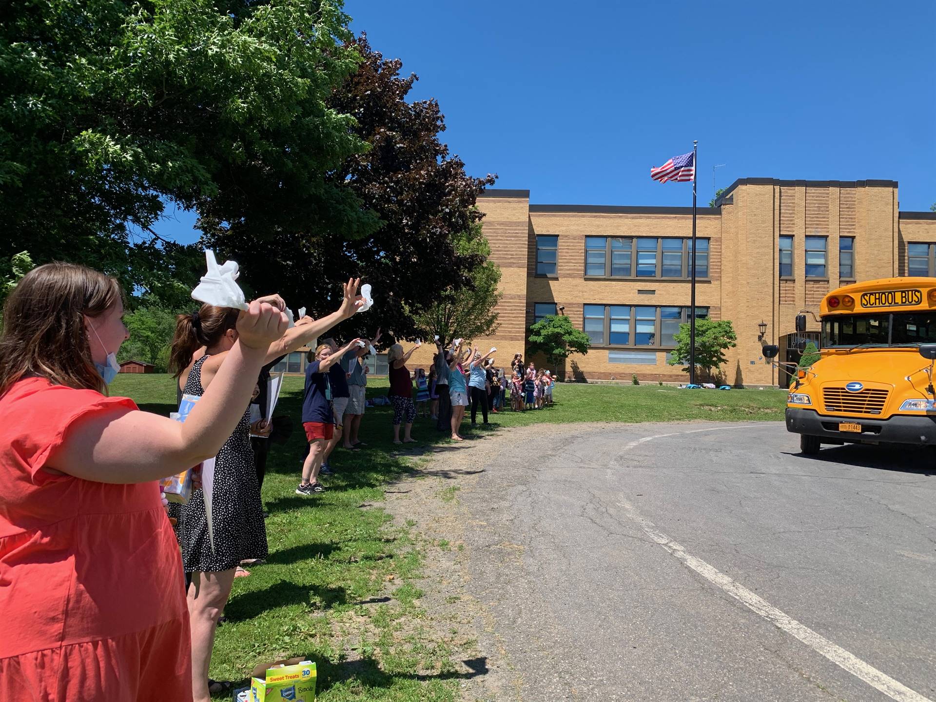 staff waves white hankies and good by signs as buses drive by