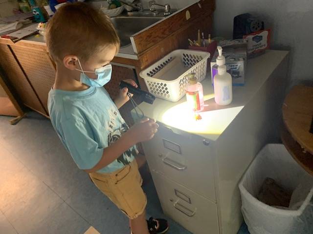 student uses flashlight to look at stuff.