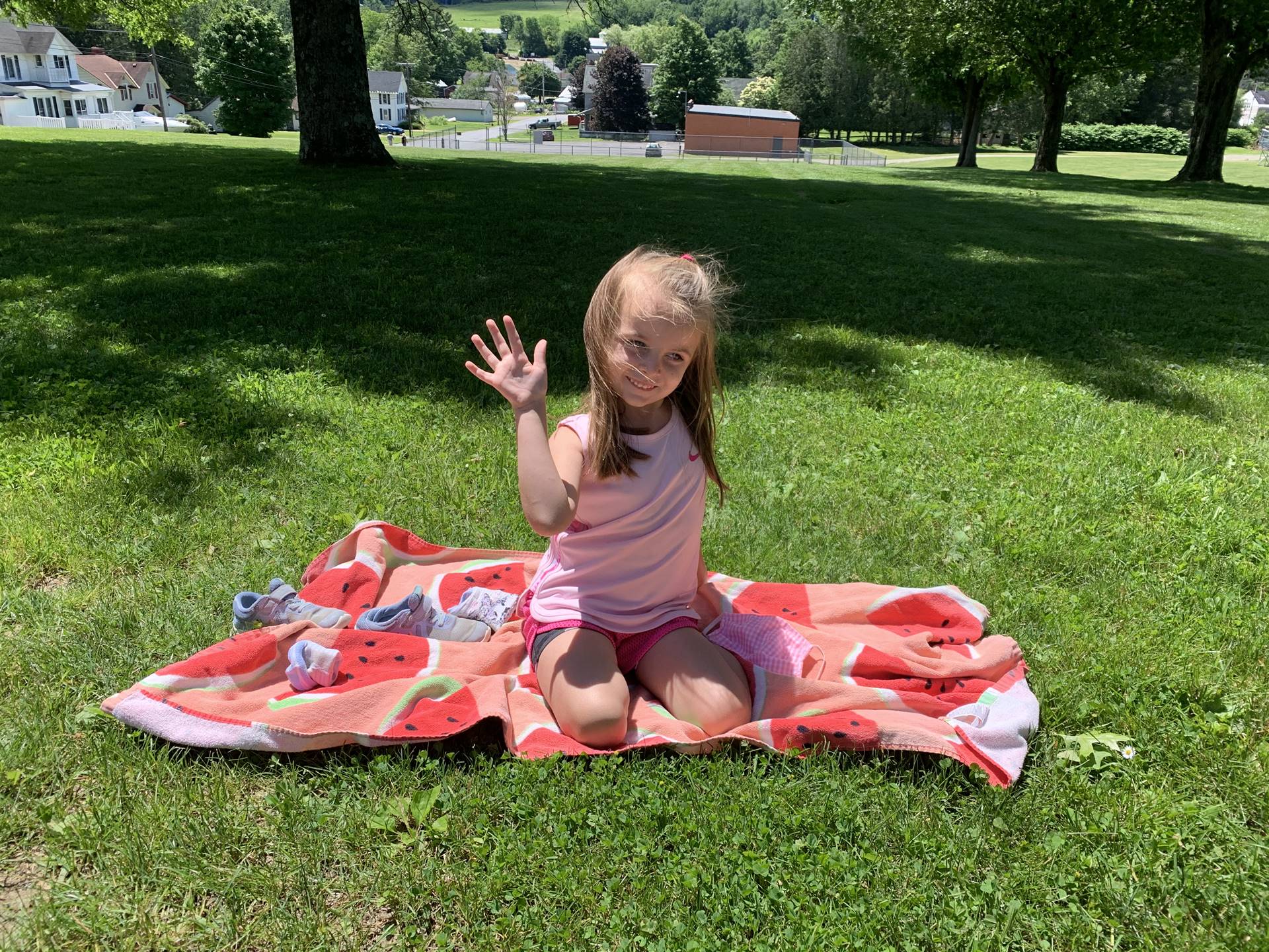 a student on a beach towel waving