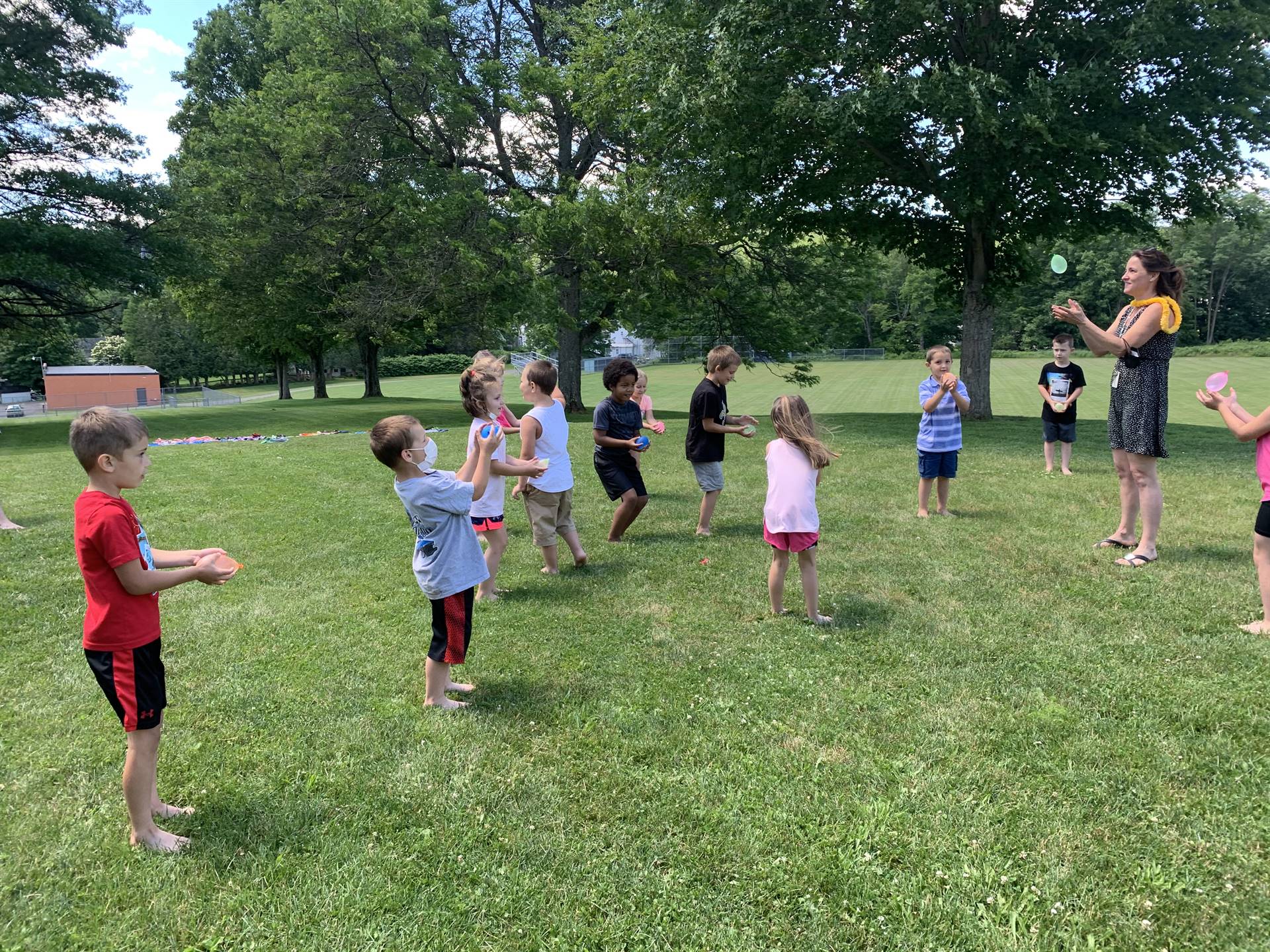 students outdoors playing with water balloons