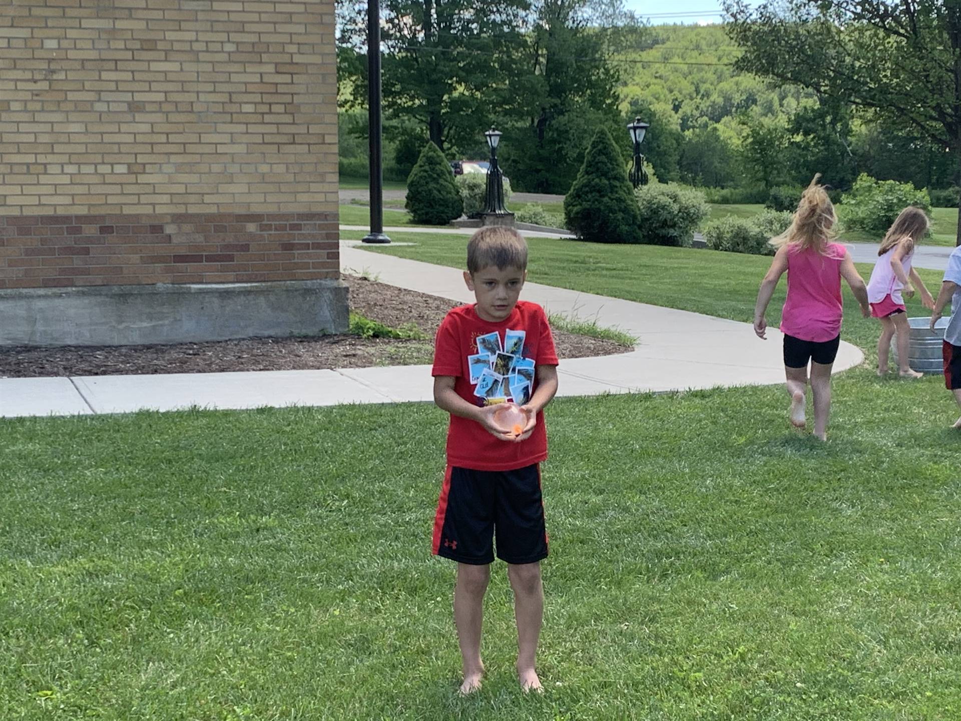 students outdoors playing with water balloons