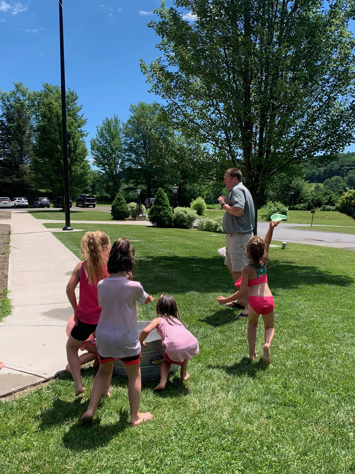 students throw water balloons at a staff member