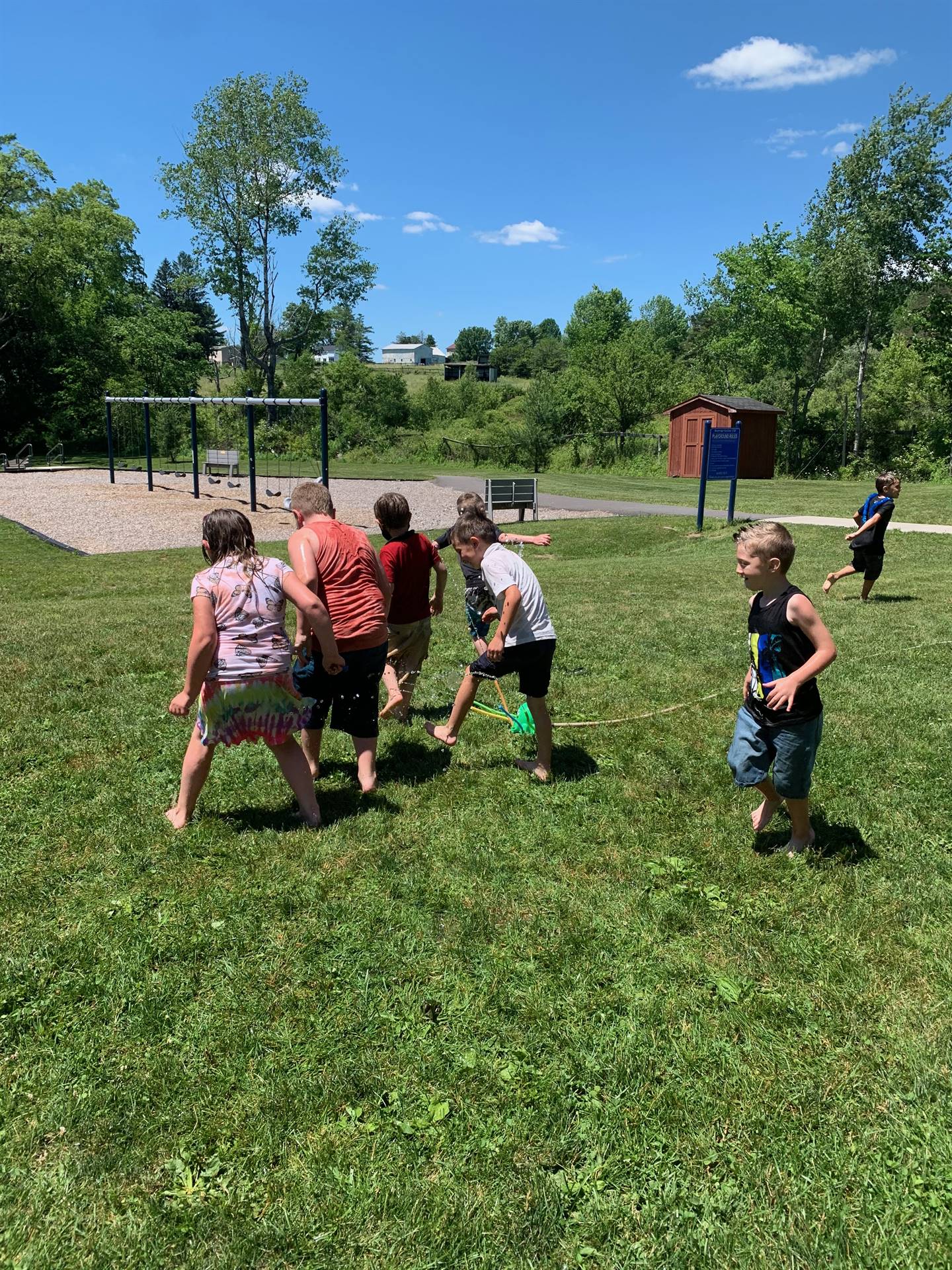 students running under sprinkler