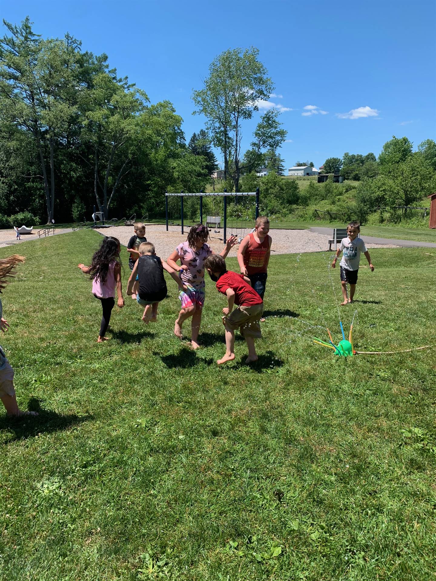 students running under sprinkler