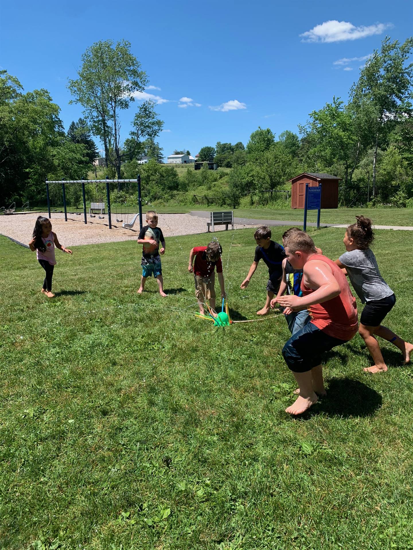 students running under sprinkler