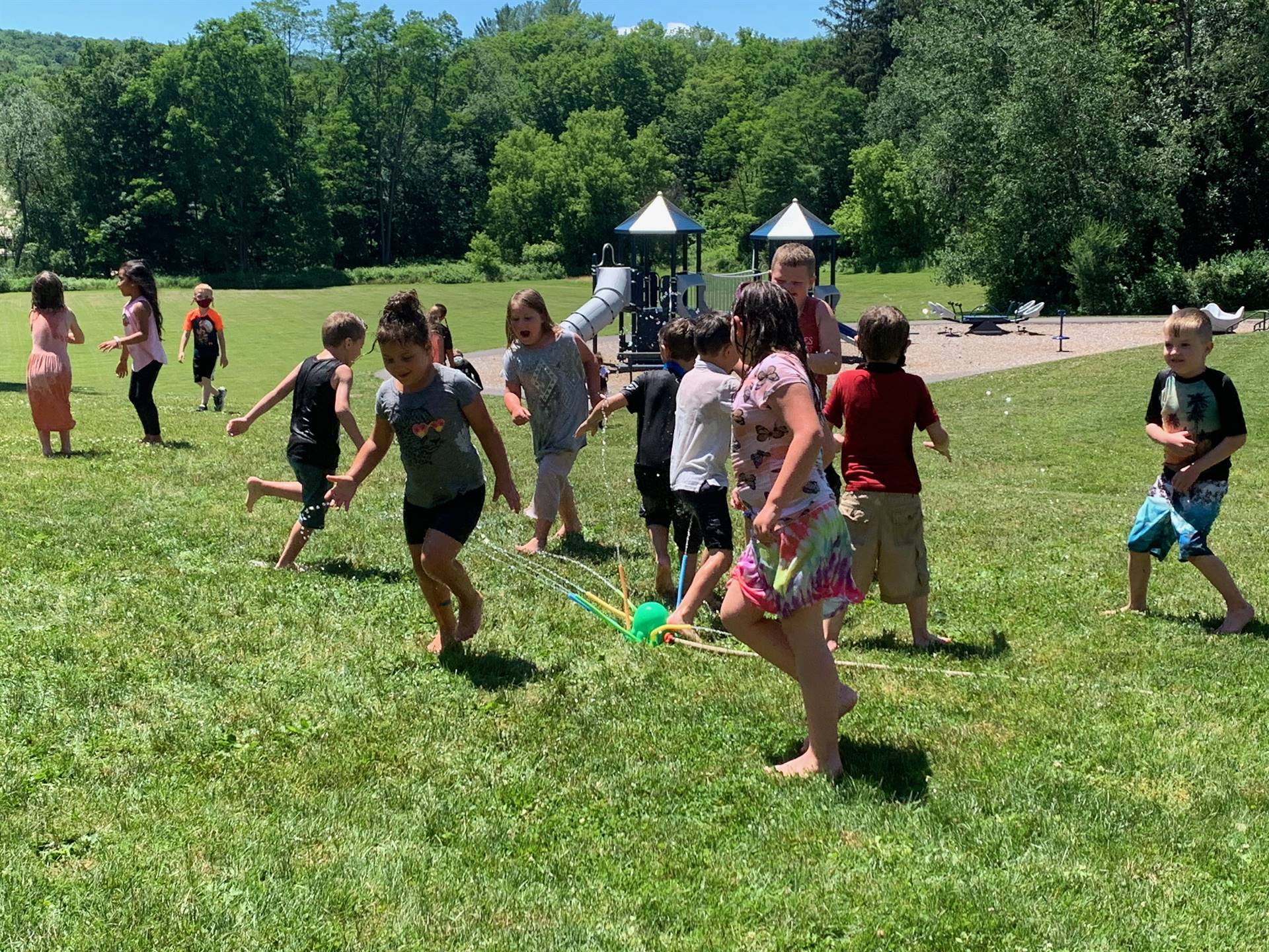 students running under sprinkler