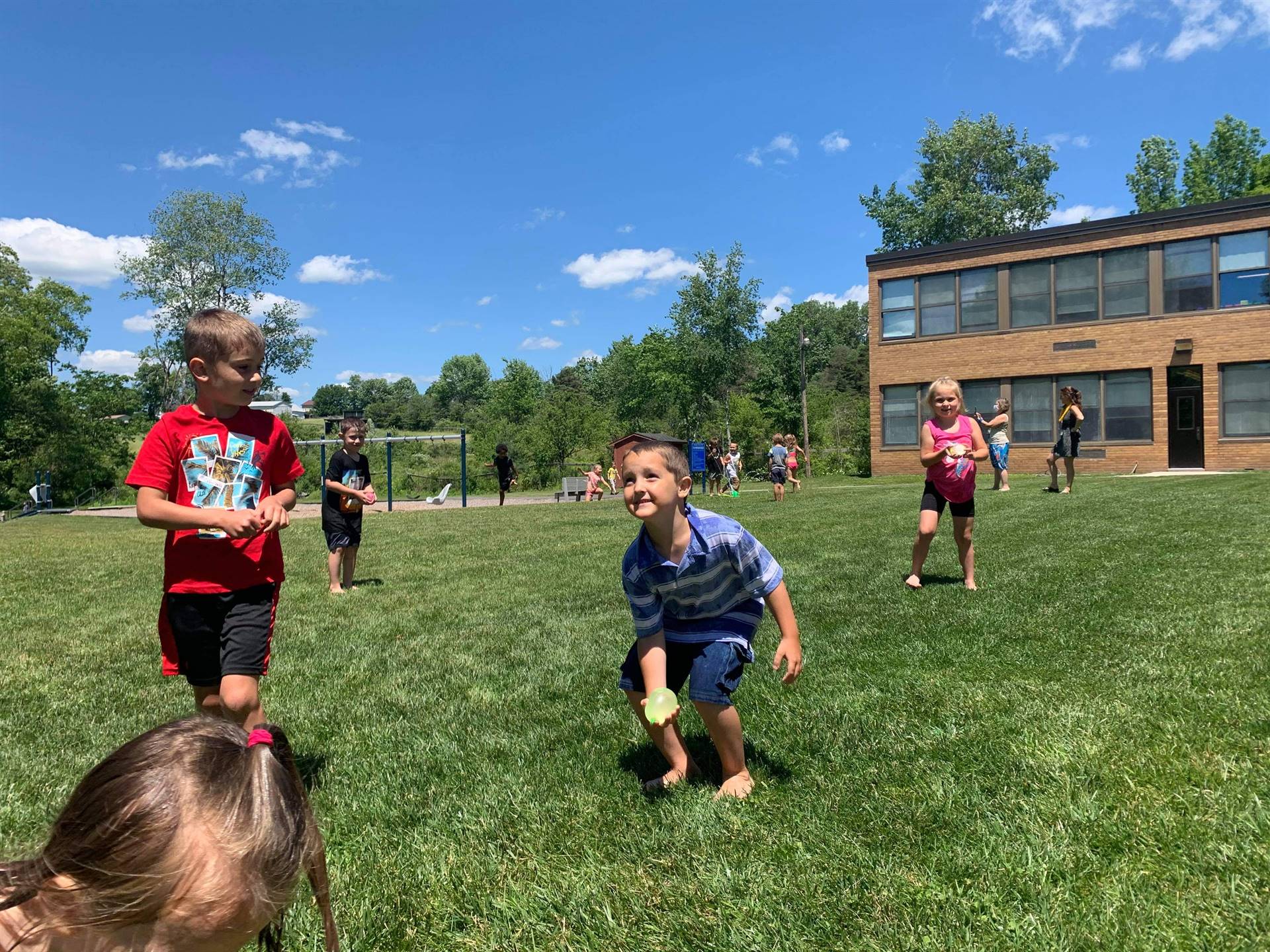 students running under sprinkler