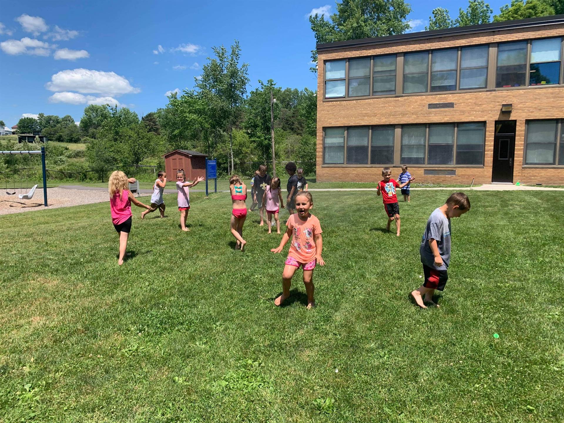 students running under sprinkler