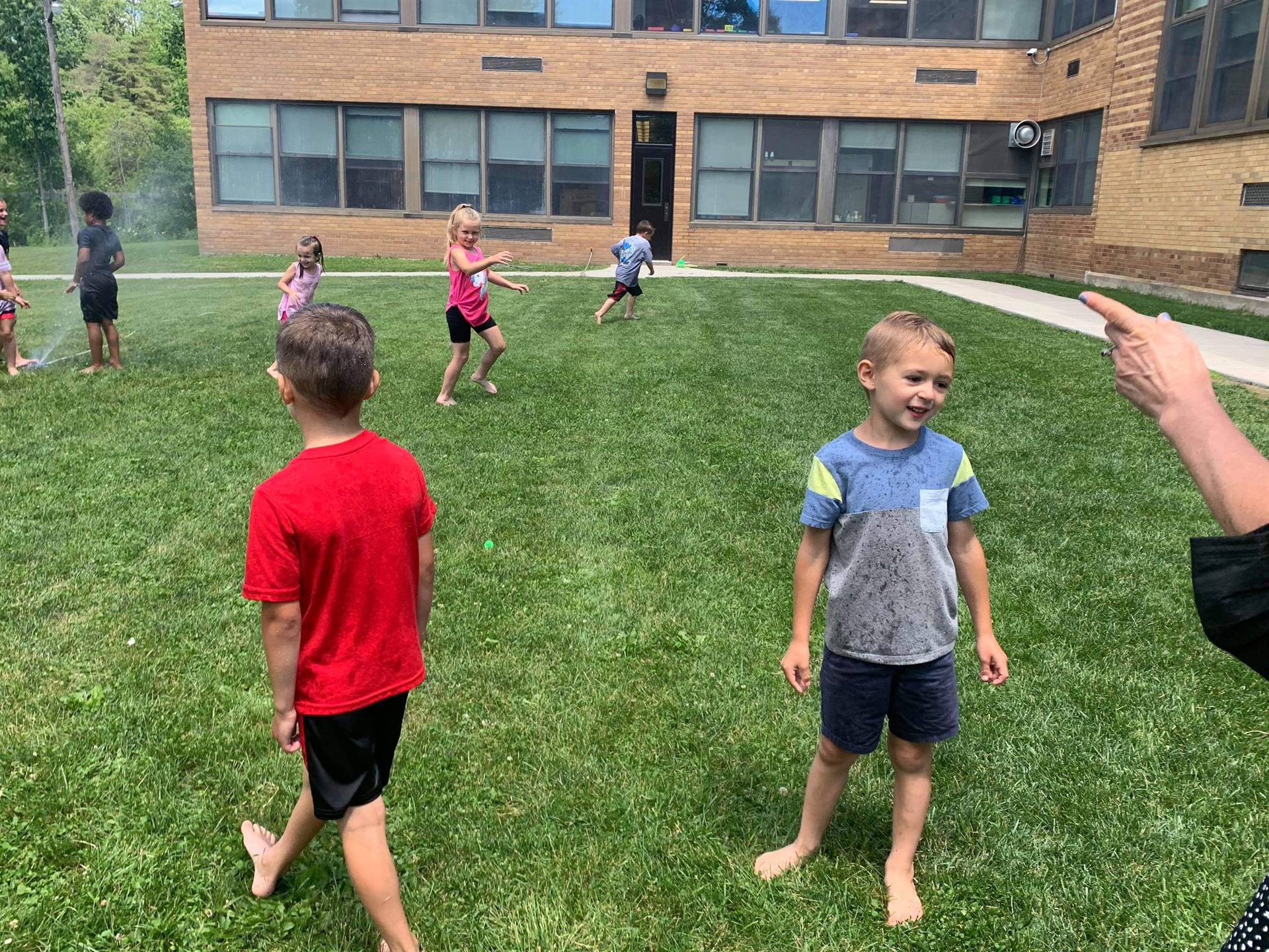 students running under sprinkler