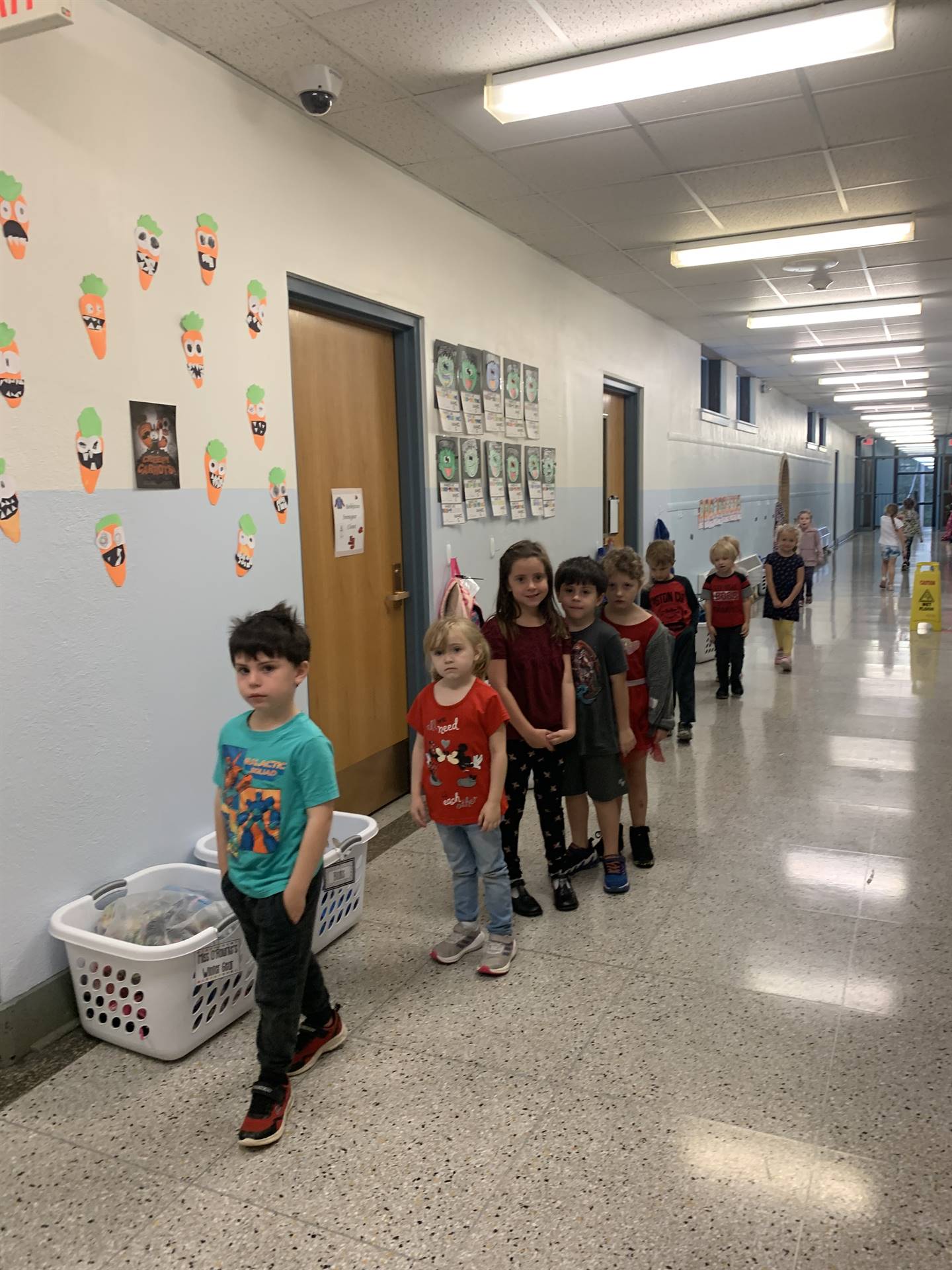 children walking safely in a line in the hallway.