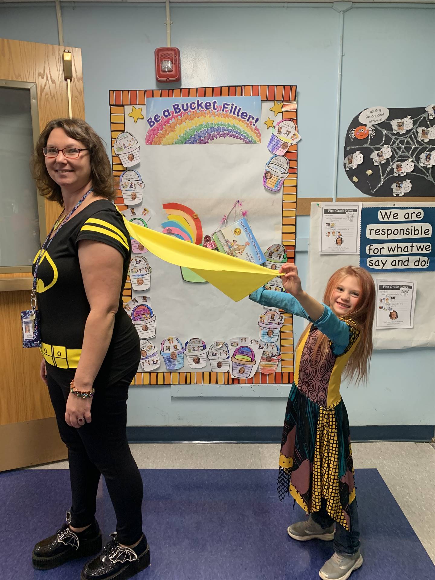 child holding the cape of an adult dressed as a superhero