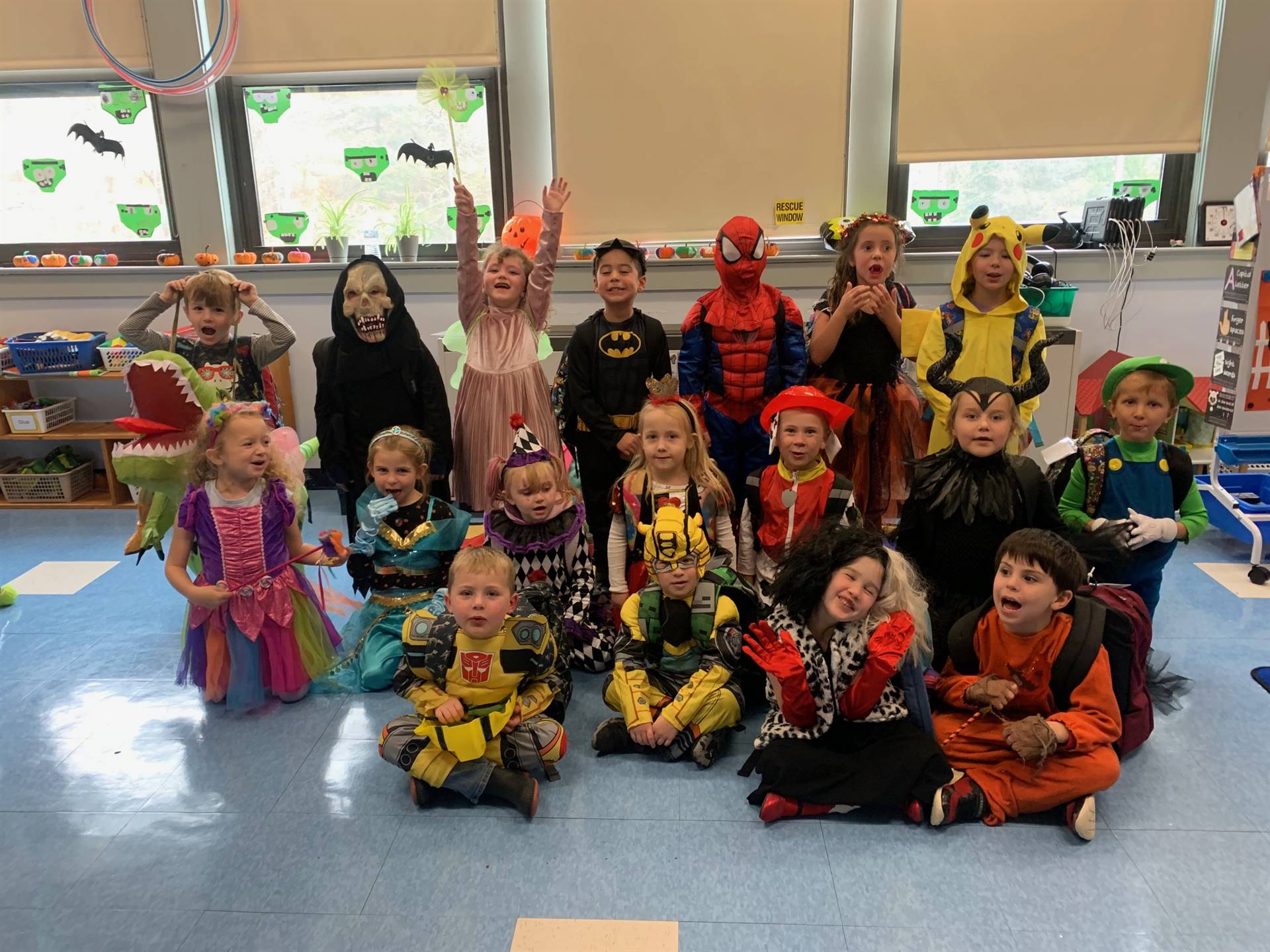 a group of students in classroom dressed in halloween costumes.