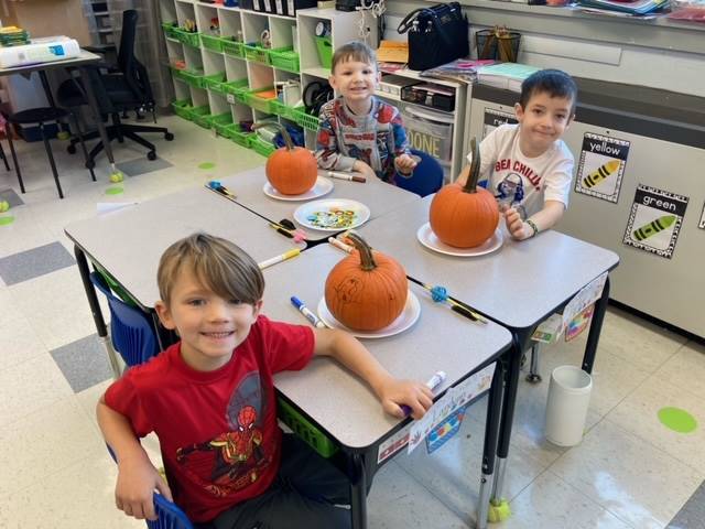 students decorating pumpkins