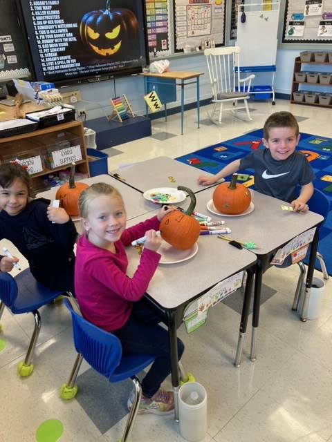 students painting pumpkins