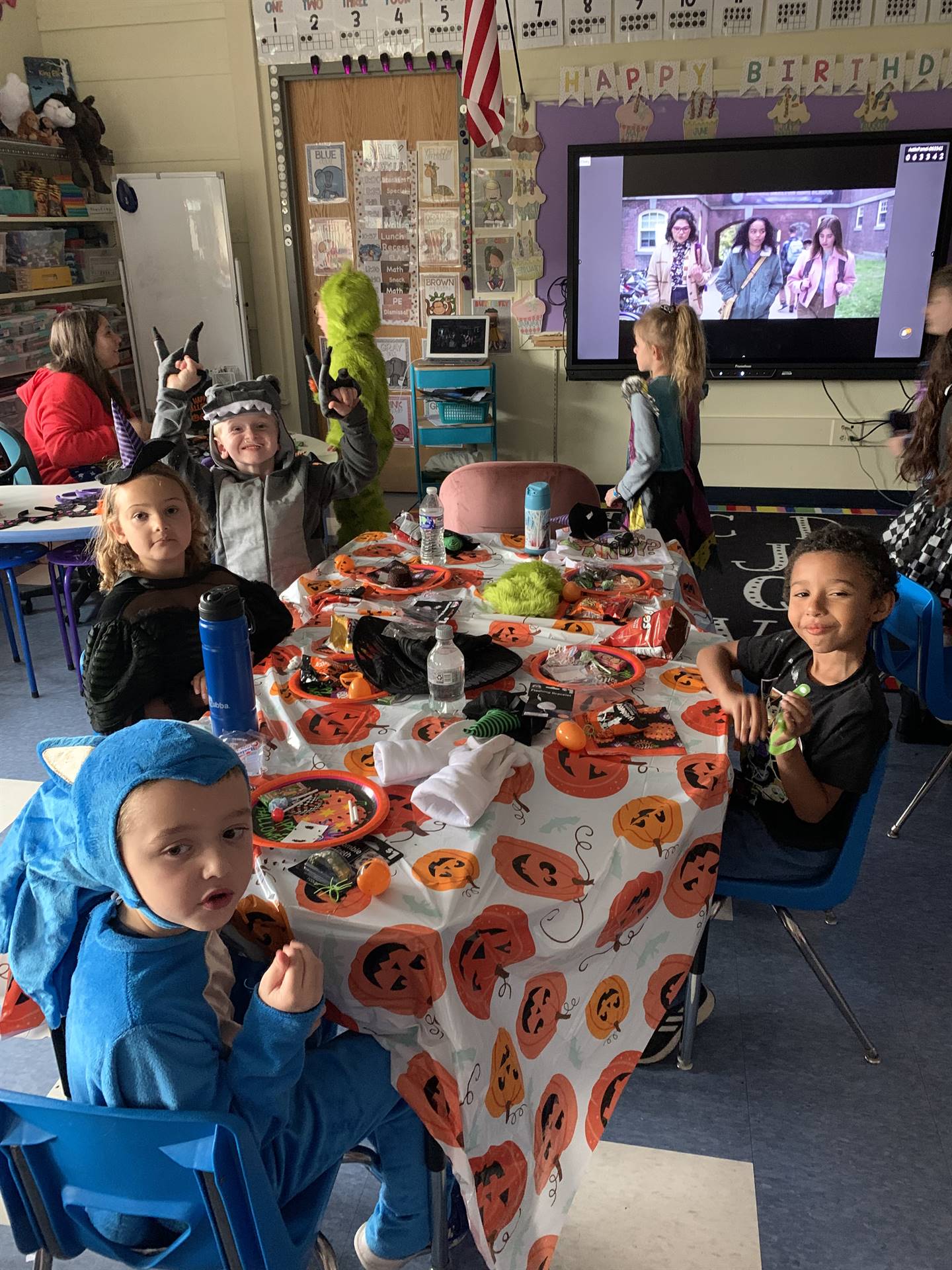 students enjoying halloween party on pumpkin table cloths