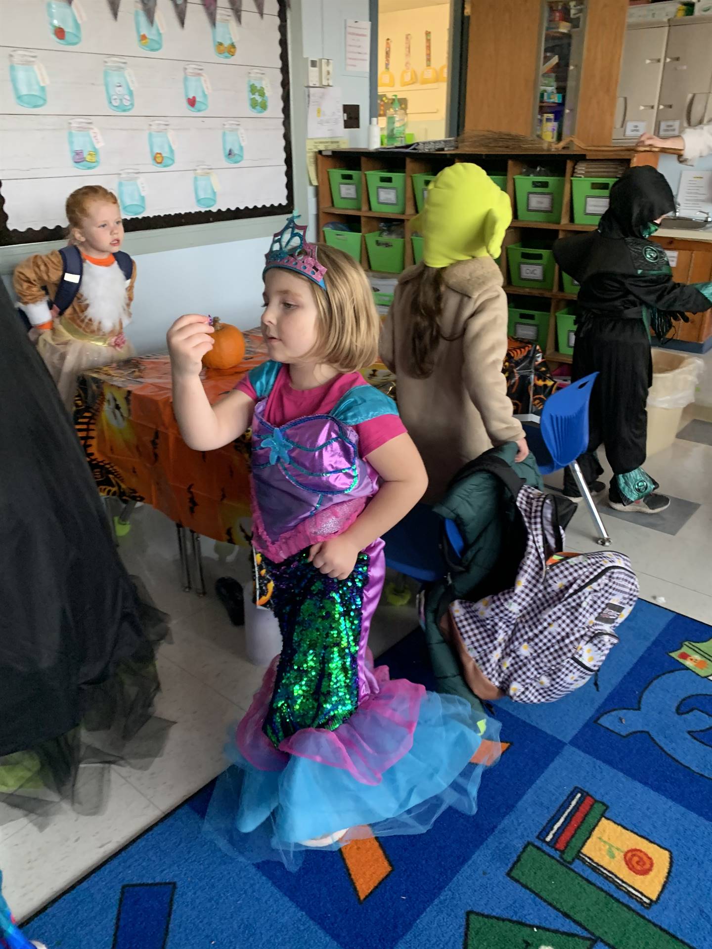 student dressed as a mermaid holding pumpkin