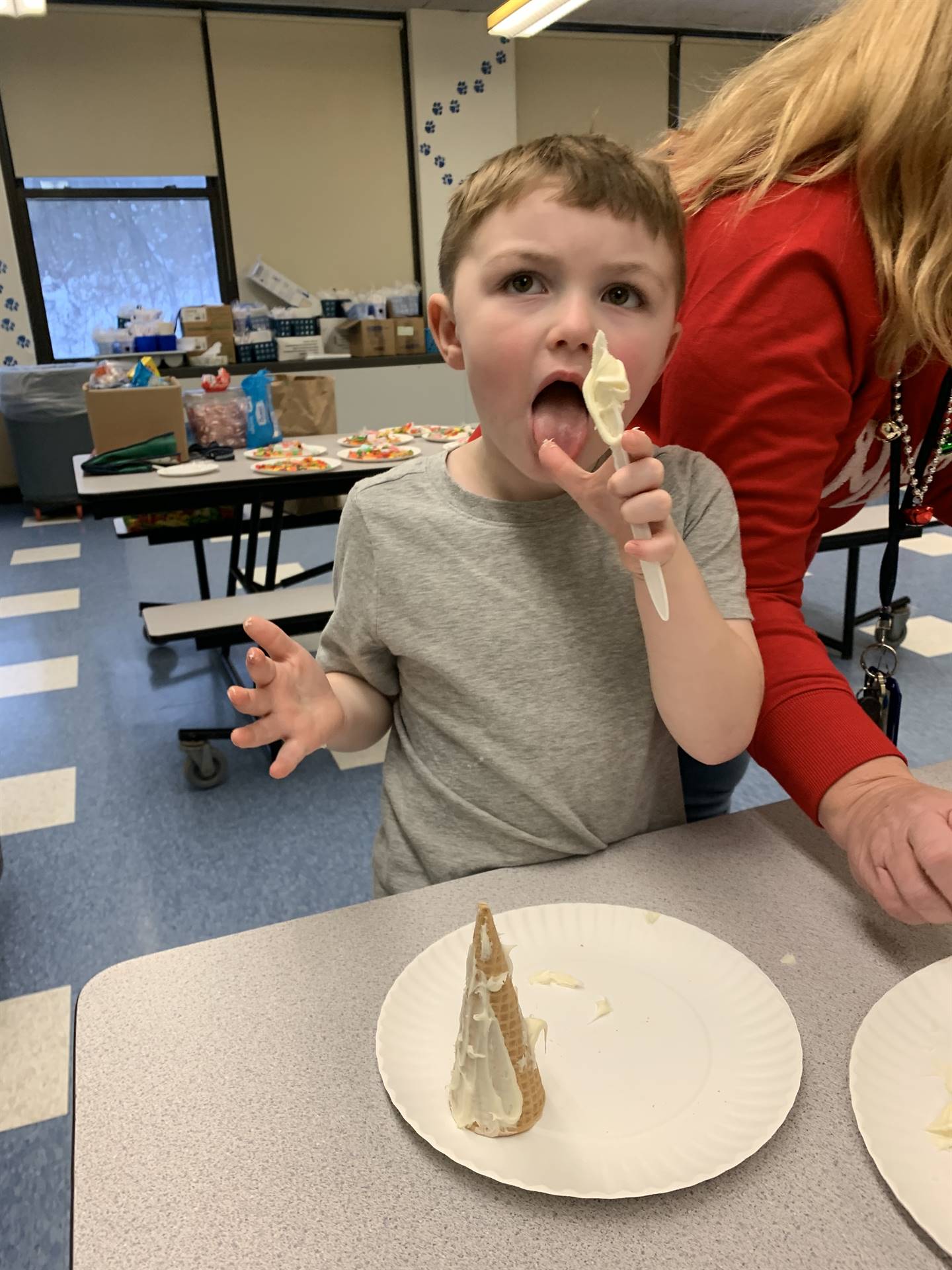 a student tastes some frosting while decorating.