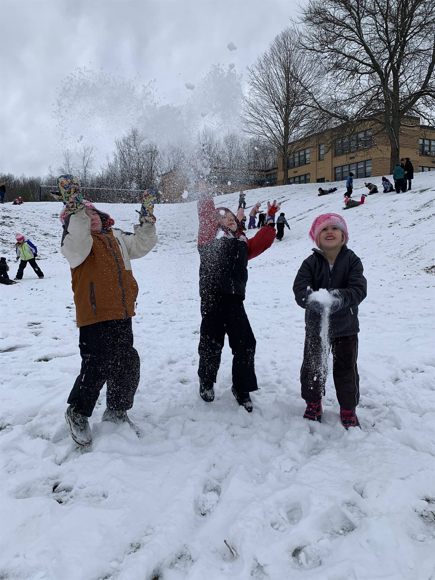 3 kids throwing snow in air