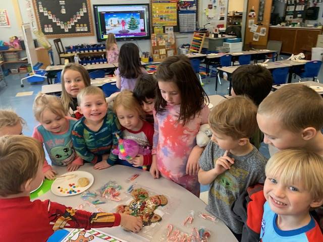 children gathered around a table looking at the gingerbread man they caught!