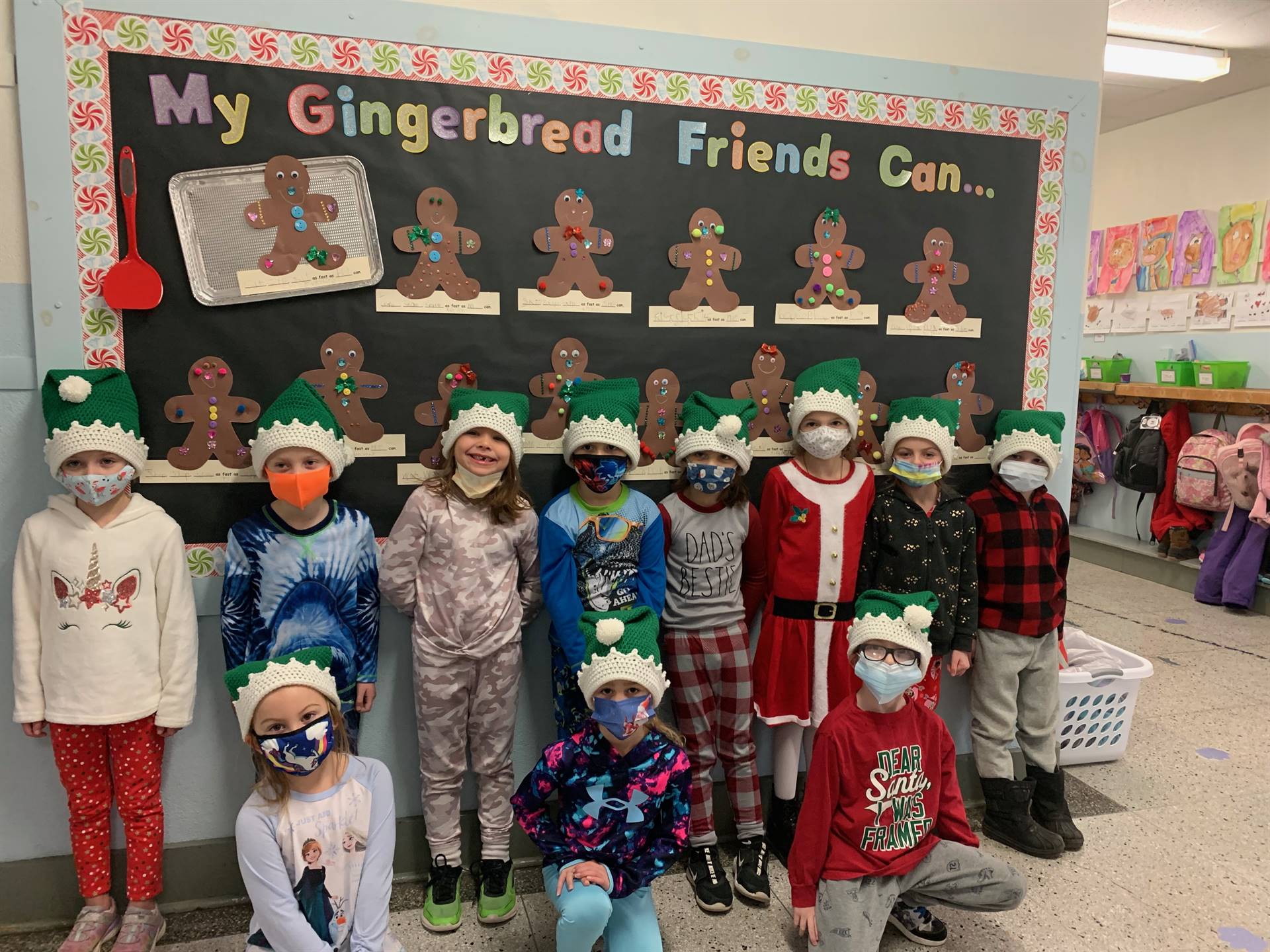 A class of students with bulletin board background with gingerbread friends. 