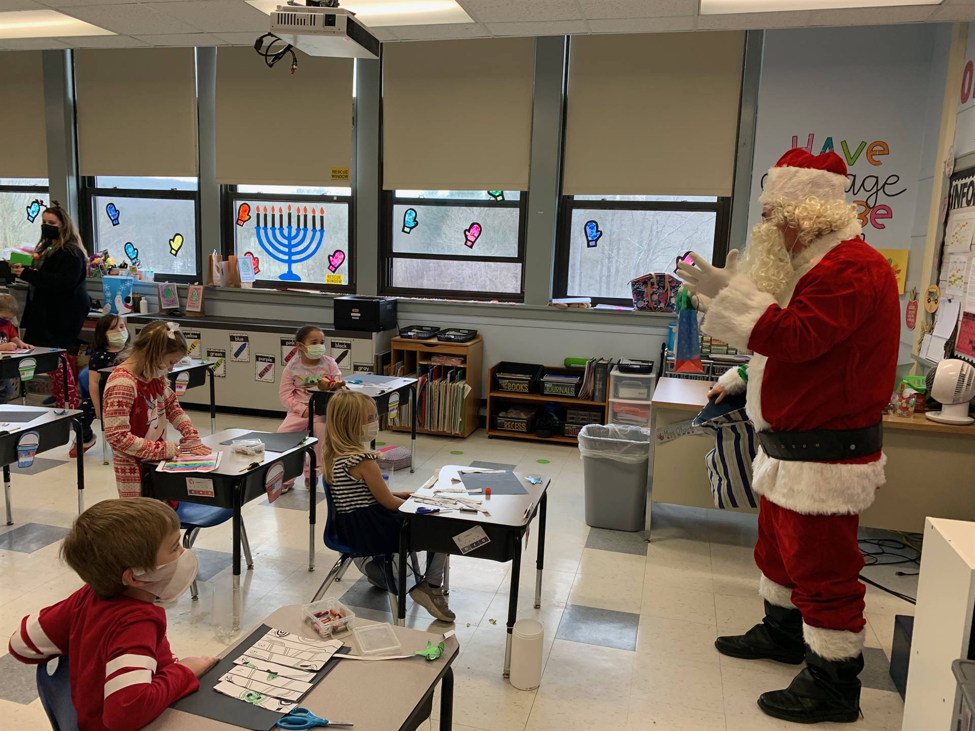 Santa talks with group of students and reads who is on the nice list. 