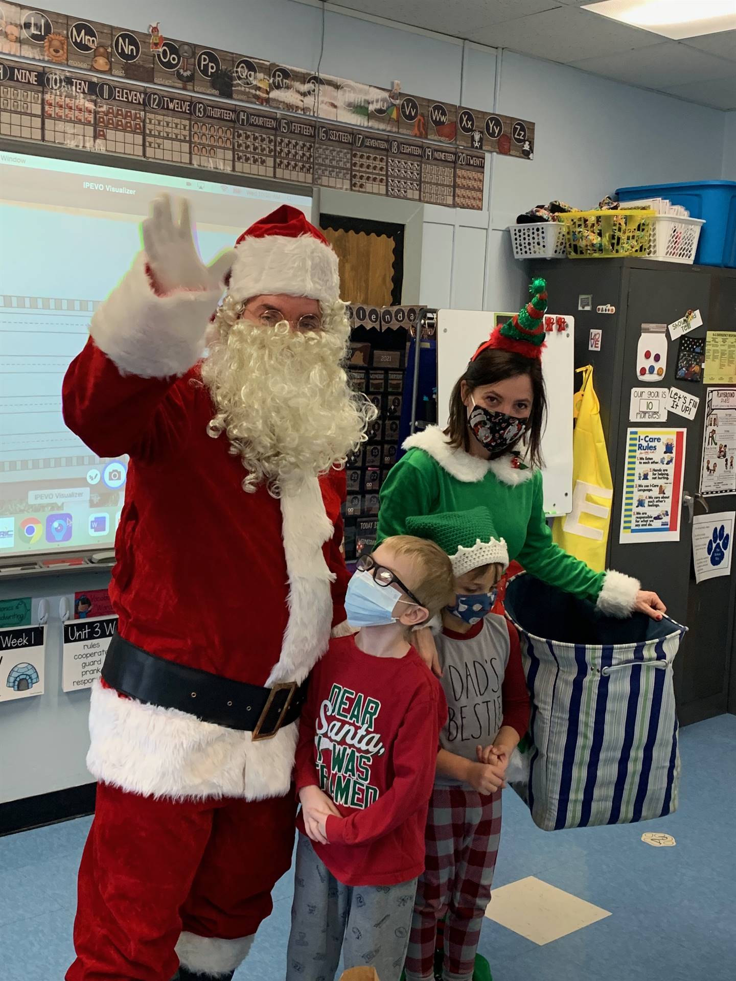 Santa waves with student and Elf. 