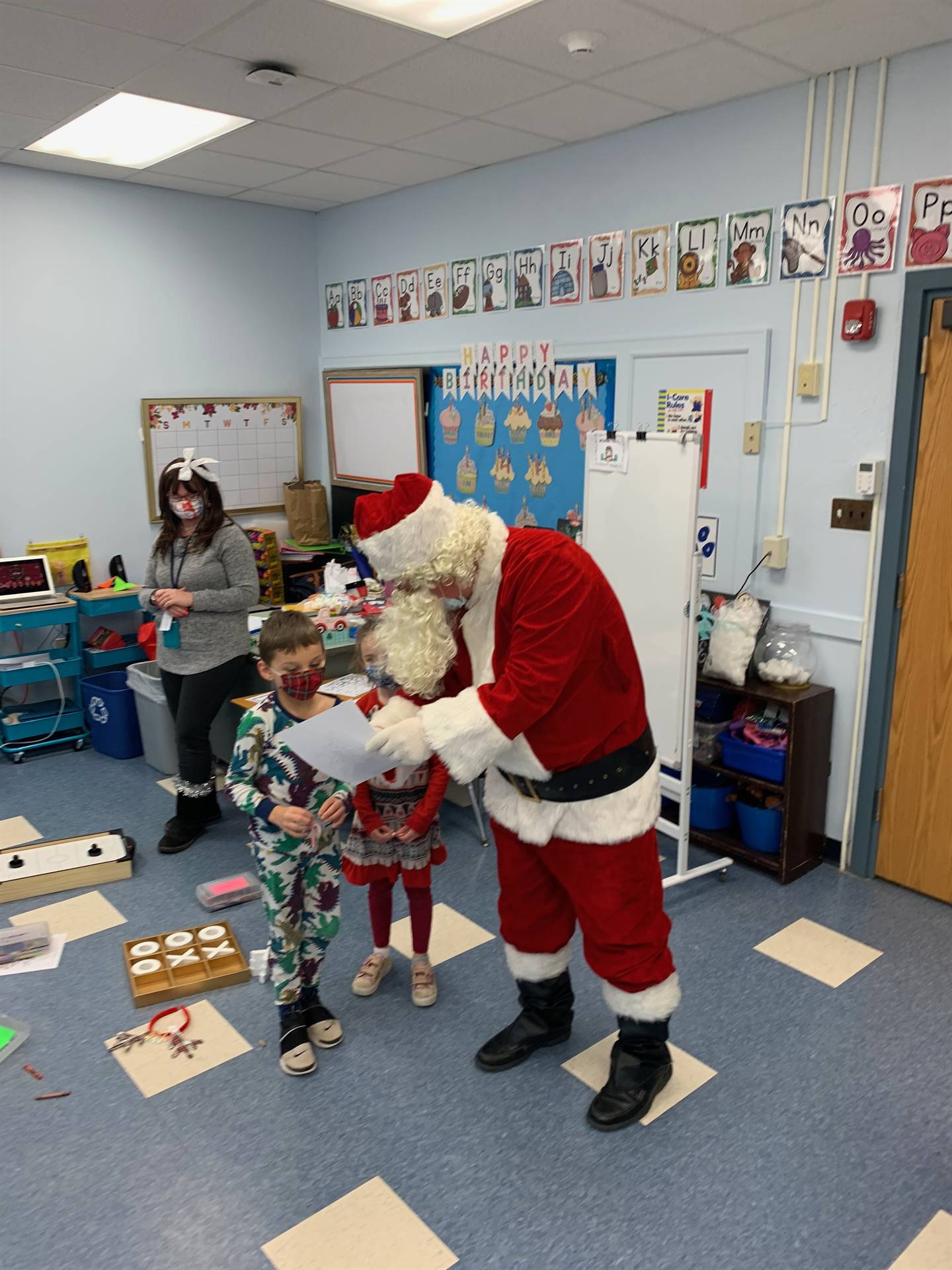 2 students hugs Santa.